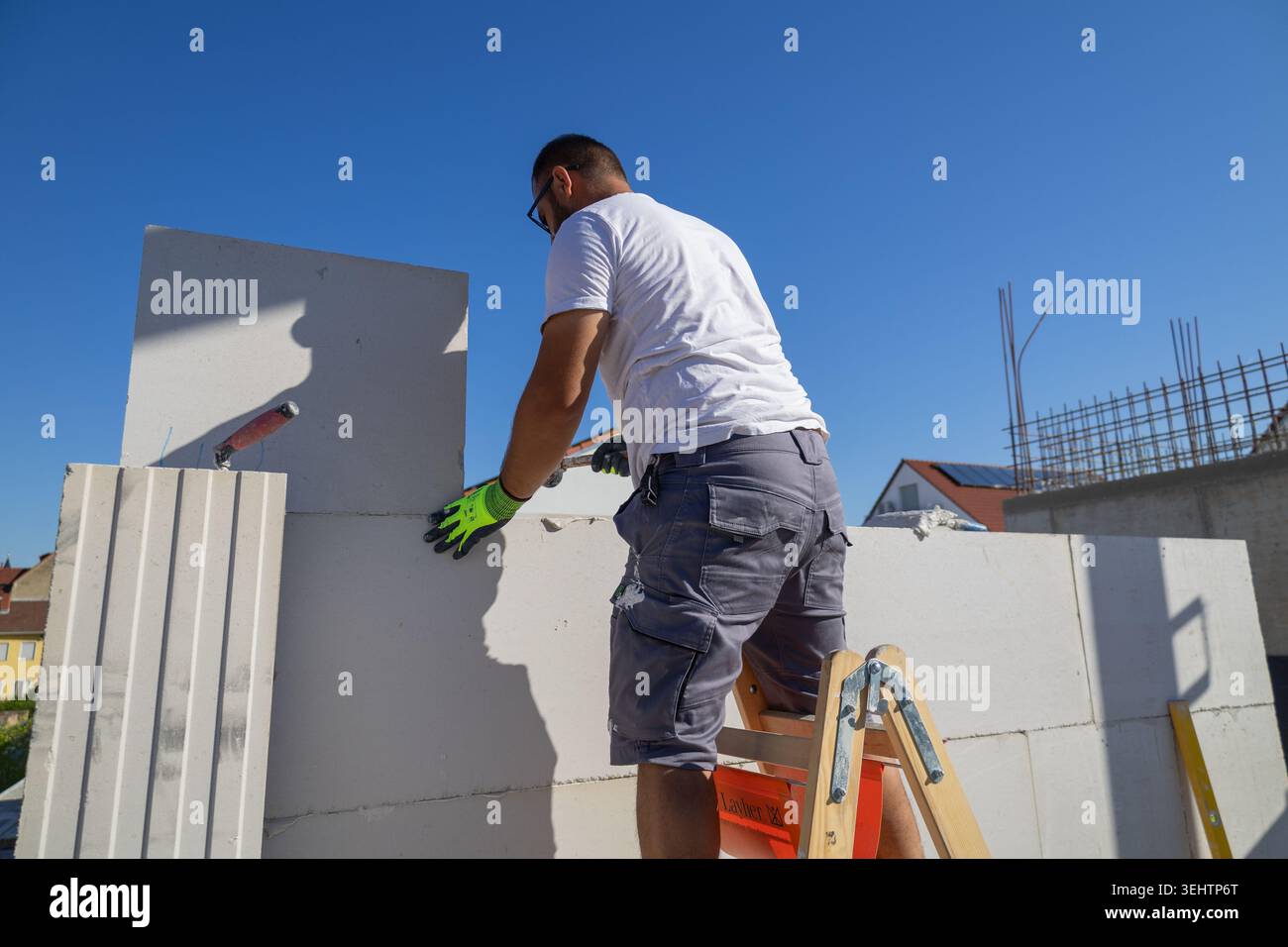 Il muratore lavora su una nuova casa indipendente Foto Stock