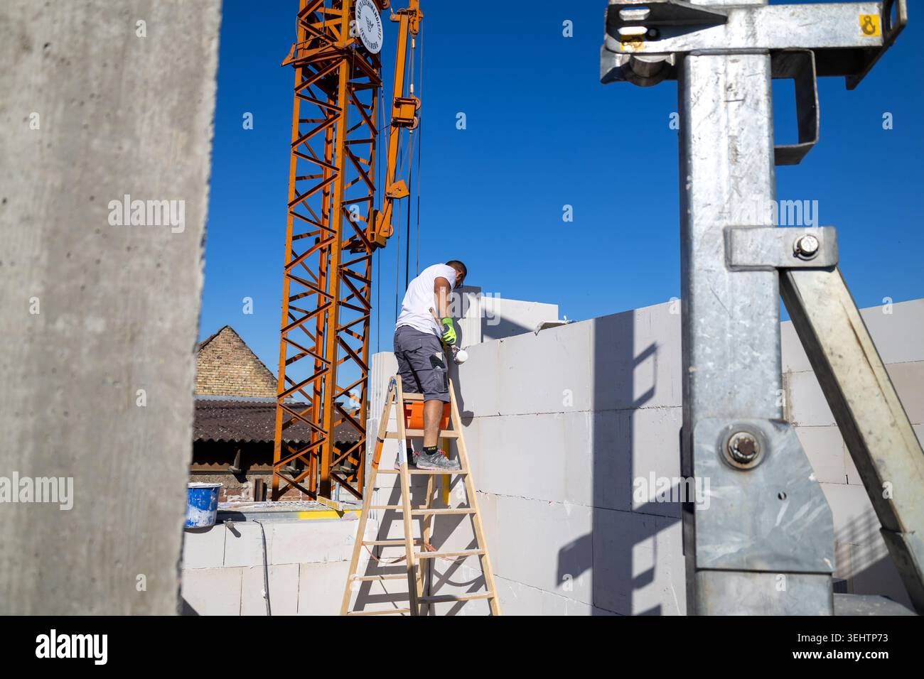 Il muratore lavora su una nuova casa indipendente Foto Stock