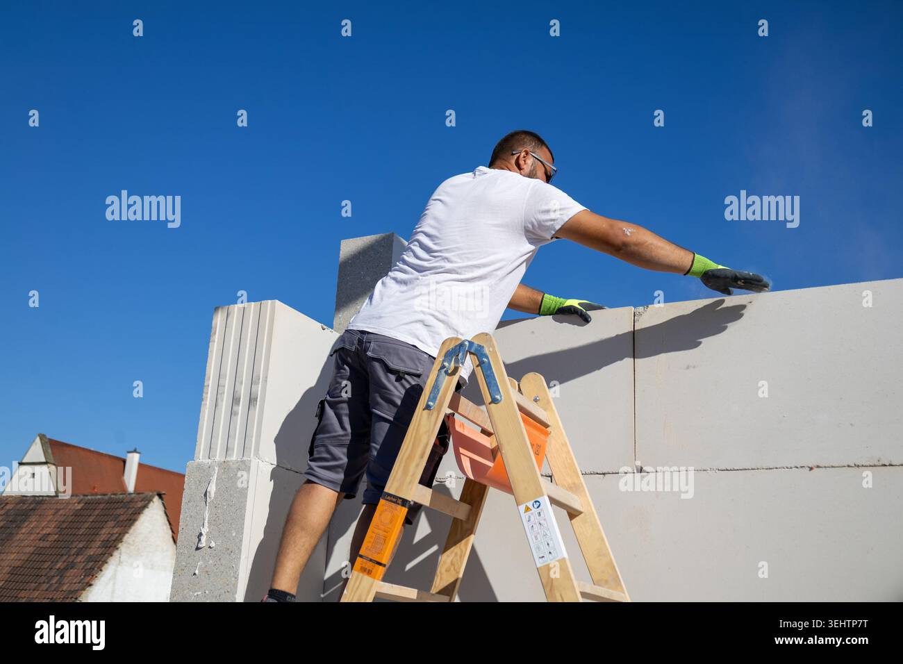Il muratore lavora su una nuova casa indipendente Foto Stock