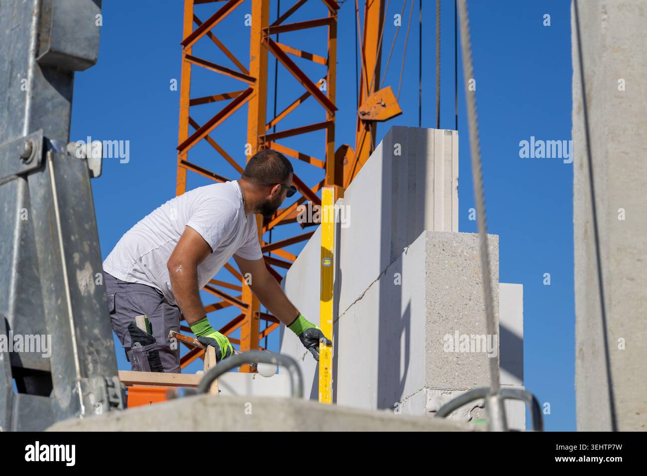 Il muratore lavora su una nuova casa indipendente Foto Stock
