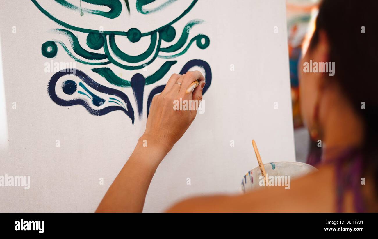 Artista che dipinge a mano colorate linee astratte pattern su tela per un progetto creativo Foto Stock