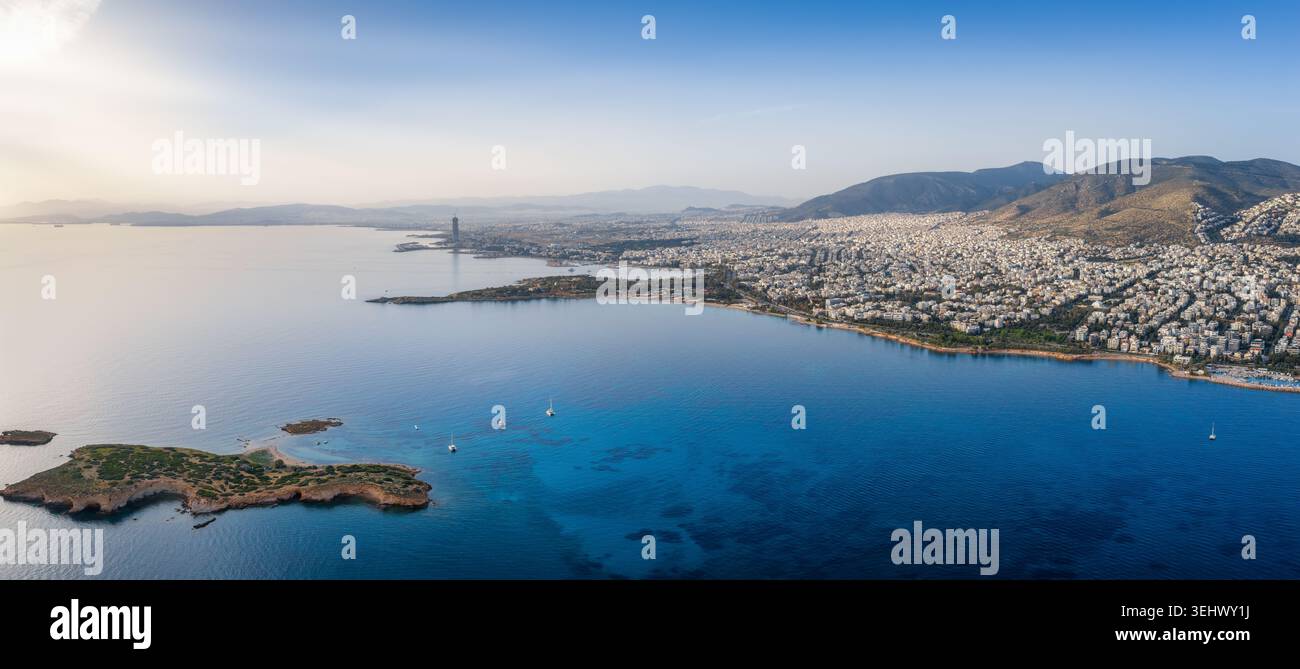 Vista aerea panoramica della costa meridionale di Atene, Grecia, con Voula, Glyfada e il quartiere Ellinikon sullo sfondo durante un calmo tramonto Foto Stock