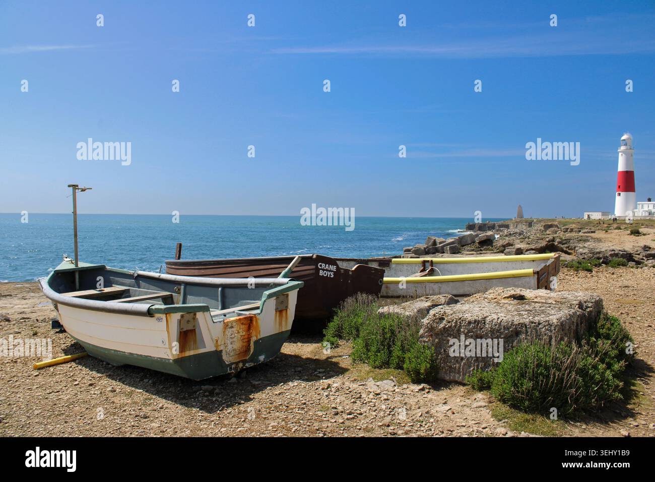 Barche da pesca tradizionali accanto al faro di Portland Bill sulla Jurassic Coast nel Dorset, in Inghilterra, in una brillante giornata estiva Foto Stock