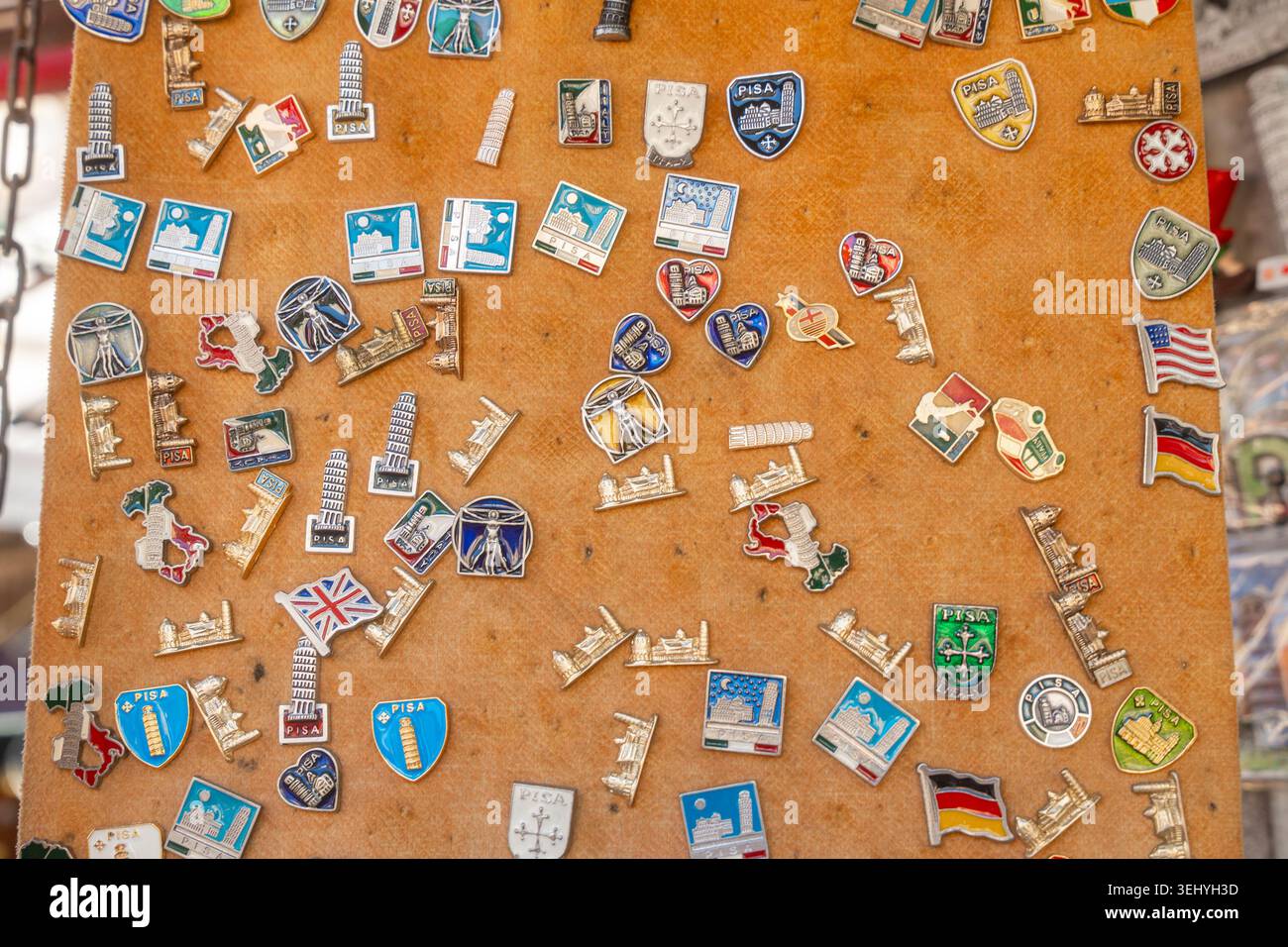 Pisa, Italia, 07.05.25, stemmi colorati in smalto che rappresentano città e regioni. Ispirazione di viaggio e atmosfera da mercato di souvenir Foto Stock