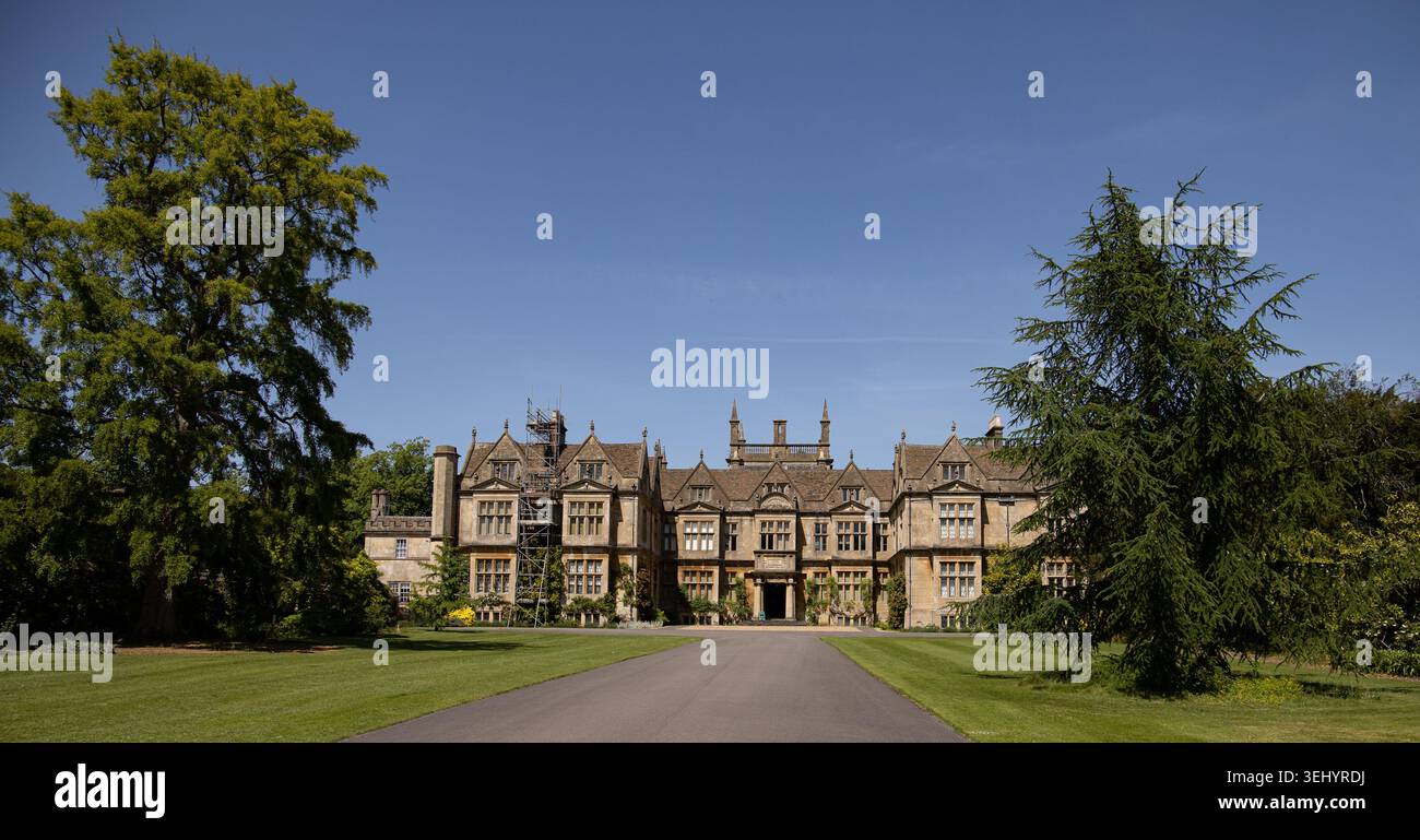 Una maestosa casa di campagna inglese con architettura in pietra ornata e ampi giardini verdi sotto un cielo estivo azzurro e limpido, Corsham Court Wiltshire Foto Stock