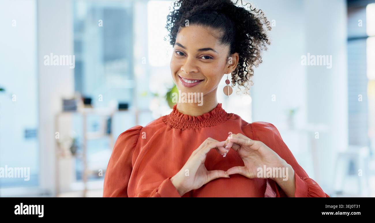 Donna felice, ritrattista e imprenditrice con le mani del cuore in ufficio per un gesto di fiducia con la carriera creativa. Sorridi, emoji e redattore di riviste femminili con amore Foto Stock