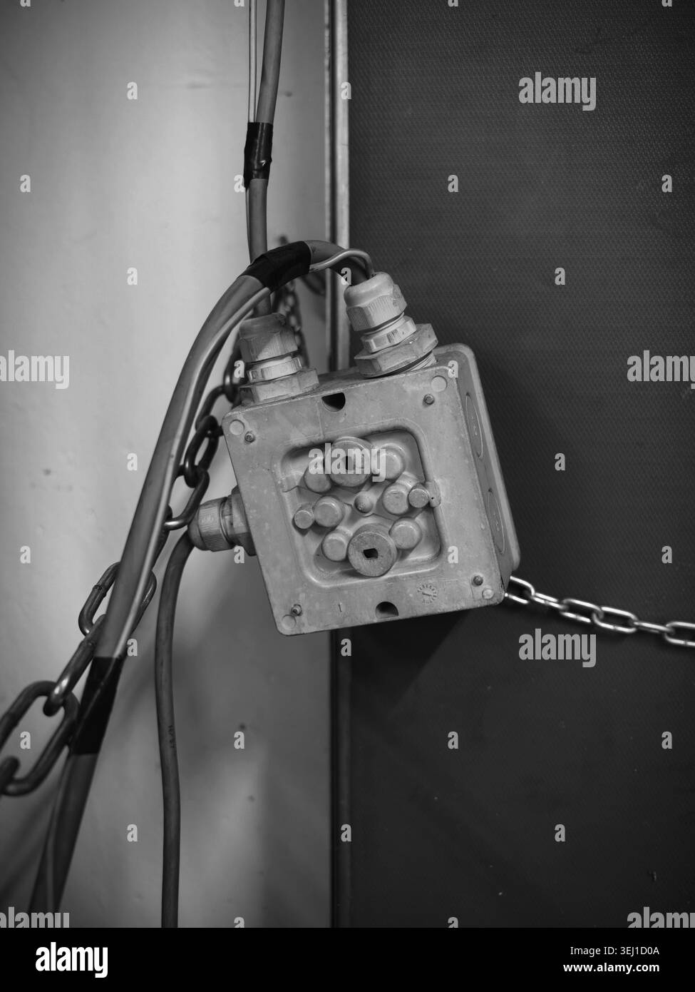 Scatola di derivazione con catena, Urbex monocromatico, vernice peeling e hardware arrugginito, contrasto intenso Foto Stock