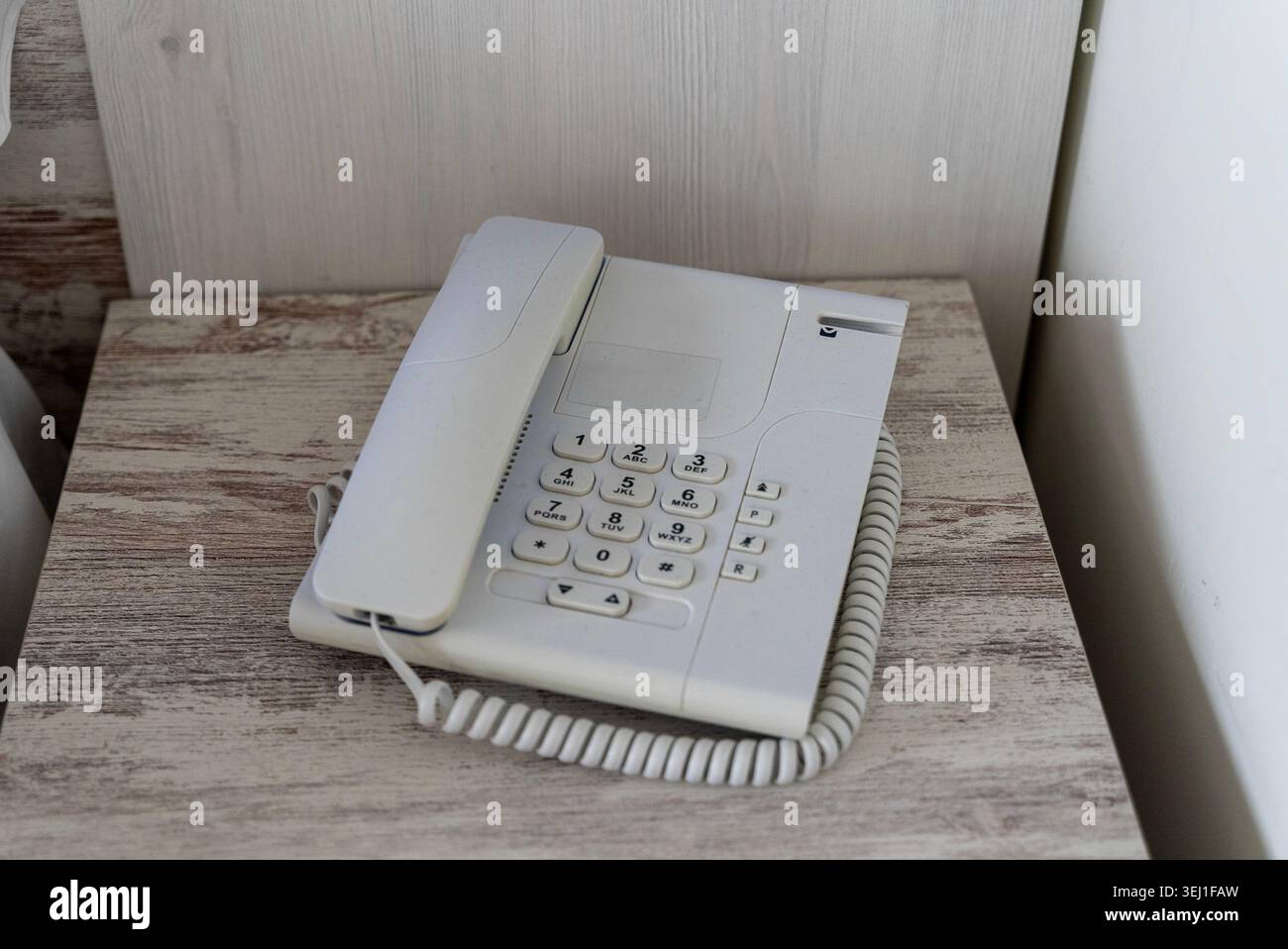 Telefono fisso bianco su tavolo in legno nelle camere dell'hotel Foto Stock