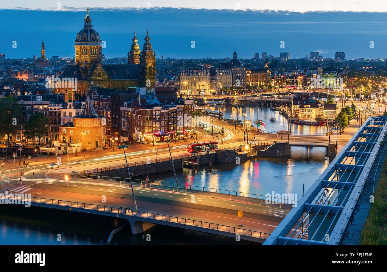 Amsterdam, Paesi Bassi, 16 maggio 2026: Vista aerea della città all'ora blu, con architettura illuminata, ponti e il fiume Amstel che riflette il cit Foto Stock