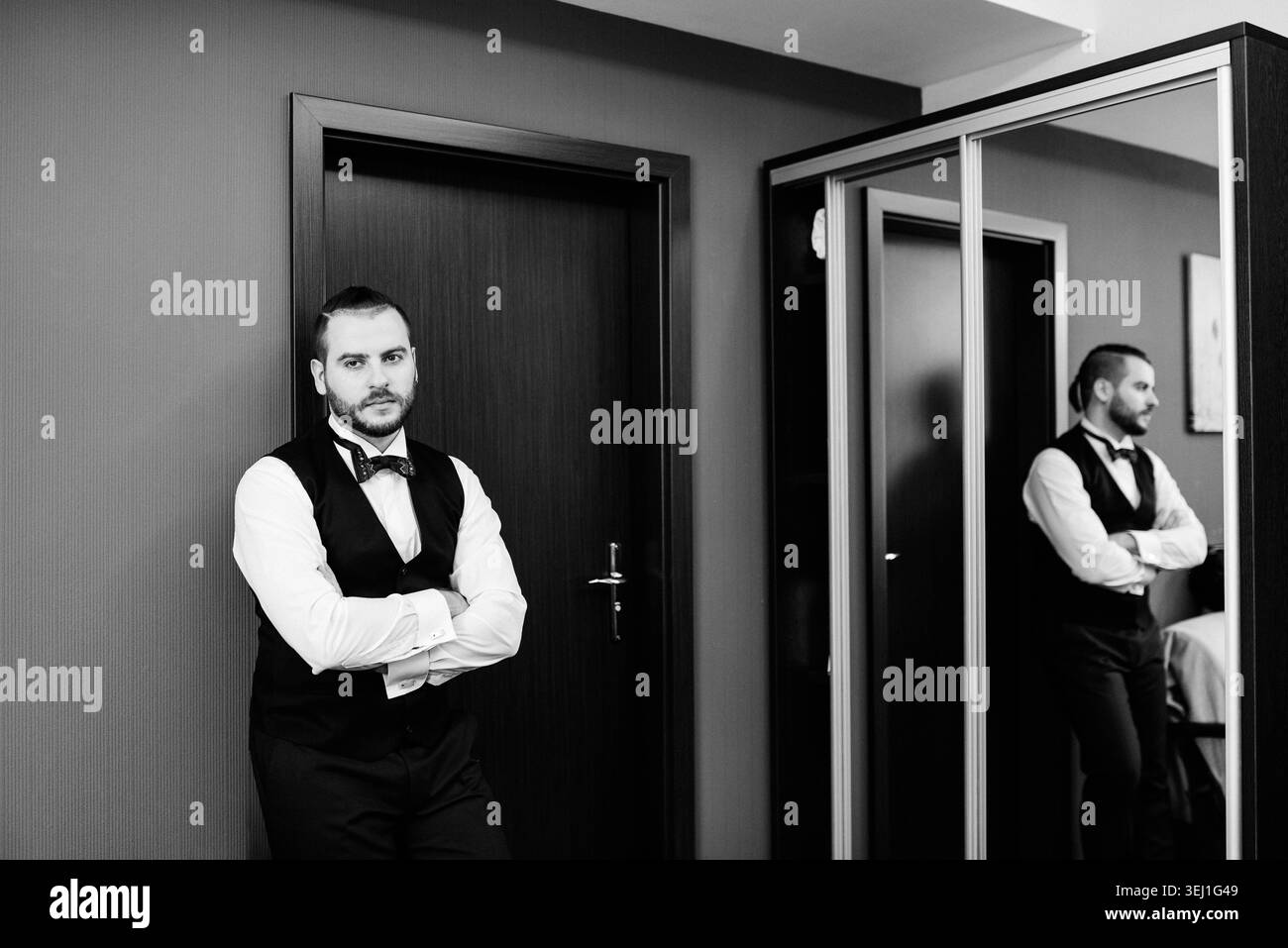 il giovane, uno sposo con la barba, si prepara per un matrimonio la mattina in una camera d'albergo Foto Stock