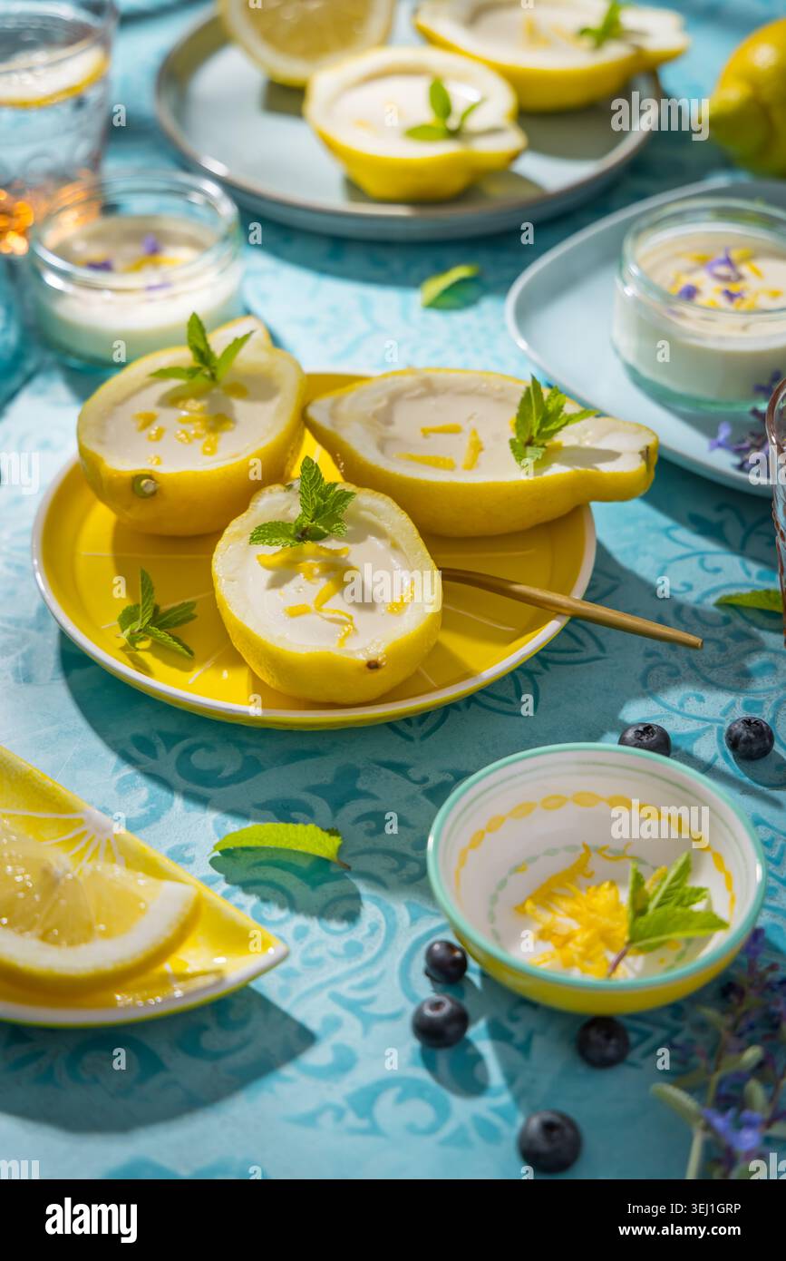 Delizioso dessert al limone servito in peel boat con menta e scorza Foto Stock