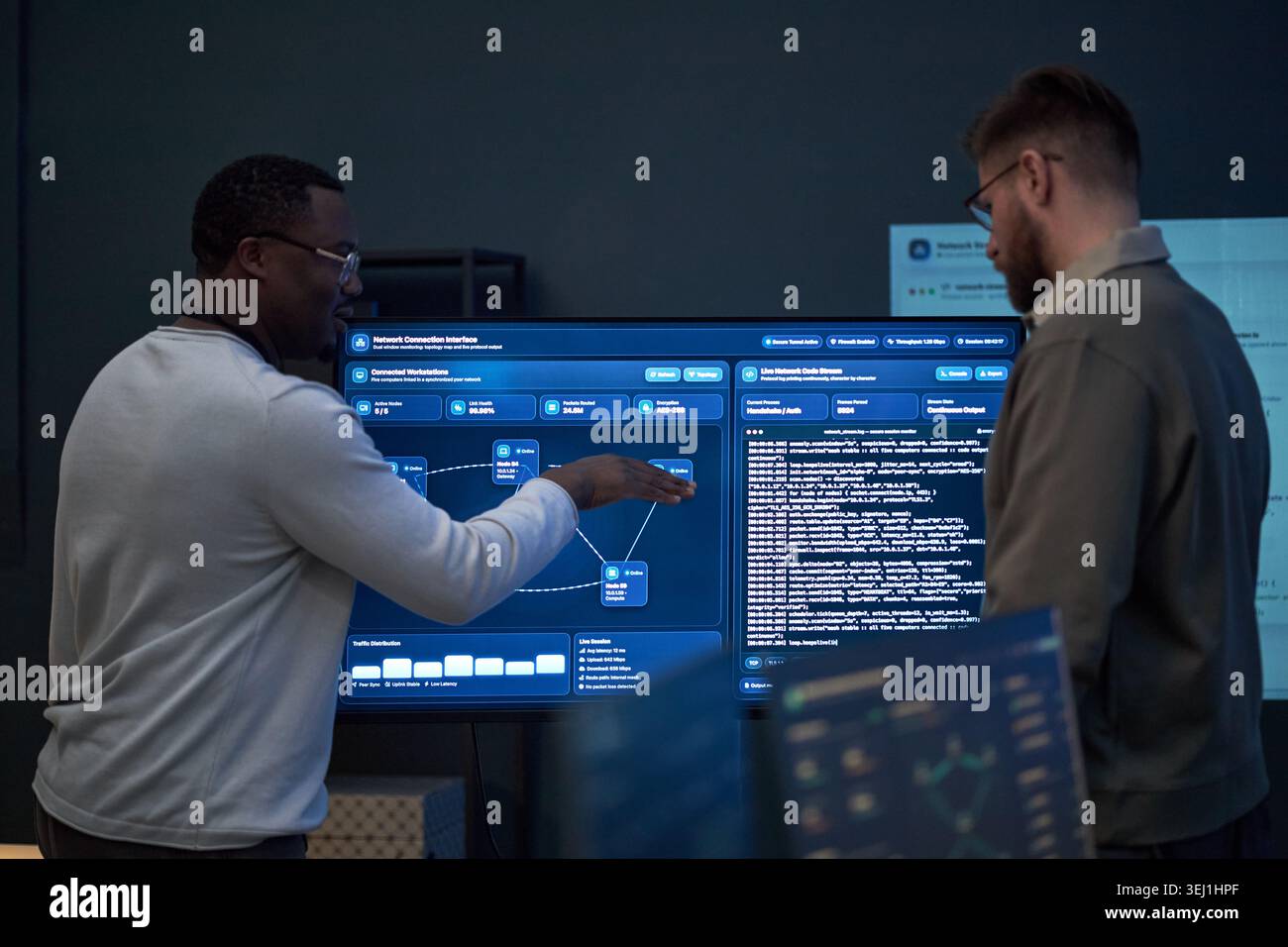 Un giovane adulto afroamericano e un giovane adulto caucasico che esamina il dashboard della rete, discute di codice e dati di sistema. Utile per la sicurezza informatica, il lavoro di squadra IT, lo sviluppo di software Foto Stock