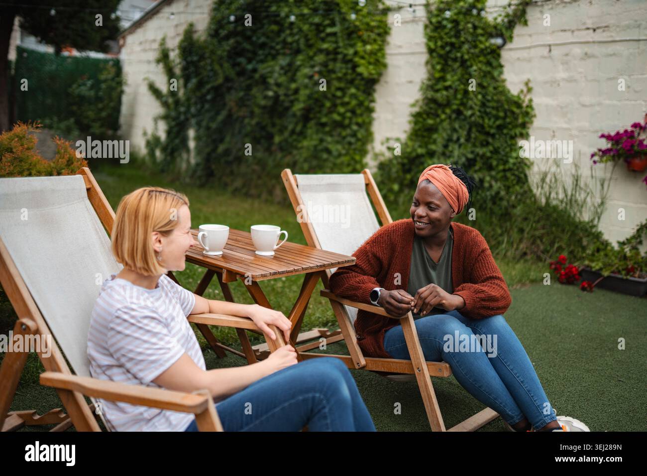 Amici diversi che si godono un caffè rilassante nel cortile Foto Stock