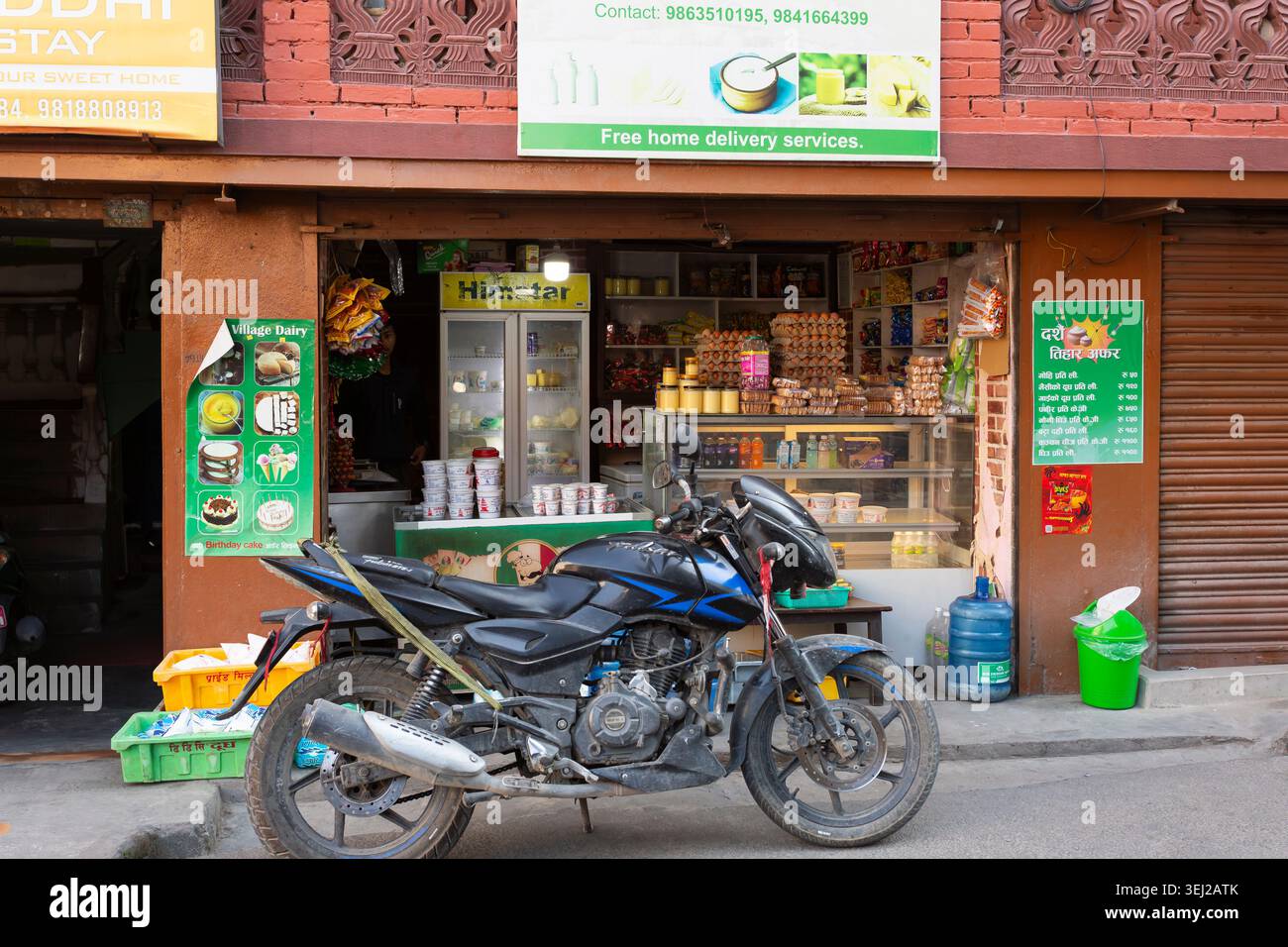 La moto è parcheggiata vicino a un piccolo negozio di alimentari nel centro di Kathmandu, Nepal Foto Stock