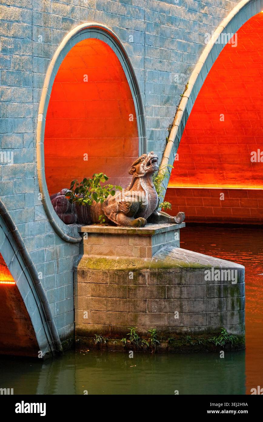 Tradizionale statua mitica del drago sul molo di pietra del ponte illuminato di Anshun, Chengdu, Sichuan, Cina Foto Stock