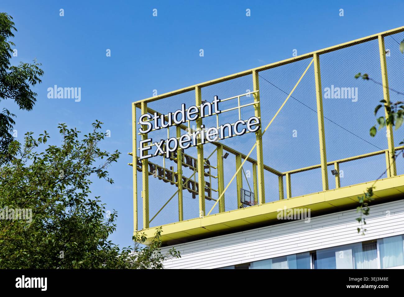 Amsterdam, Paesi Bassi - 23 maggio 2026: Grande cartello per Student Experience Housing Complex su una moderna struttura in metallo giallo contro una S blu chiaro Foto Stock