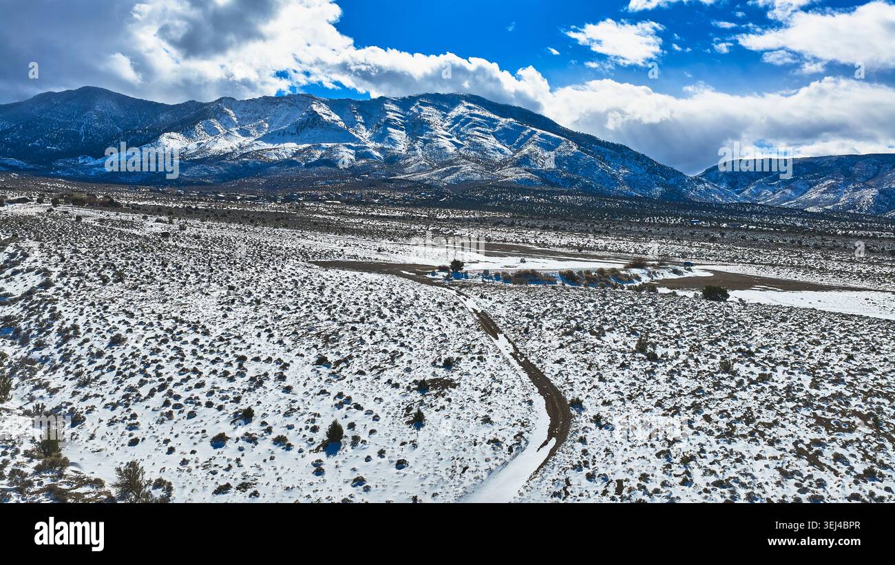 Aerial Snow Covered Road e la vegetazione del deserto con le montagne del Monte Charleston Nevada Foto Stock