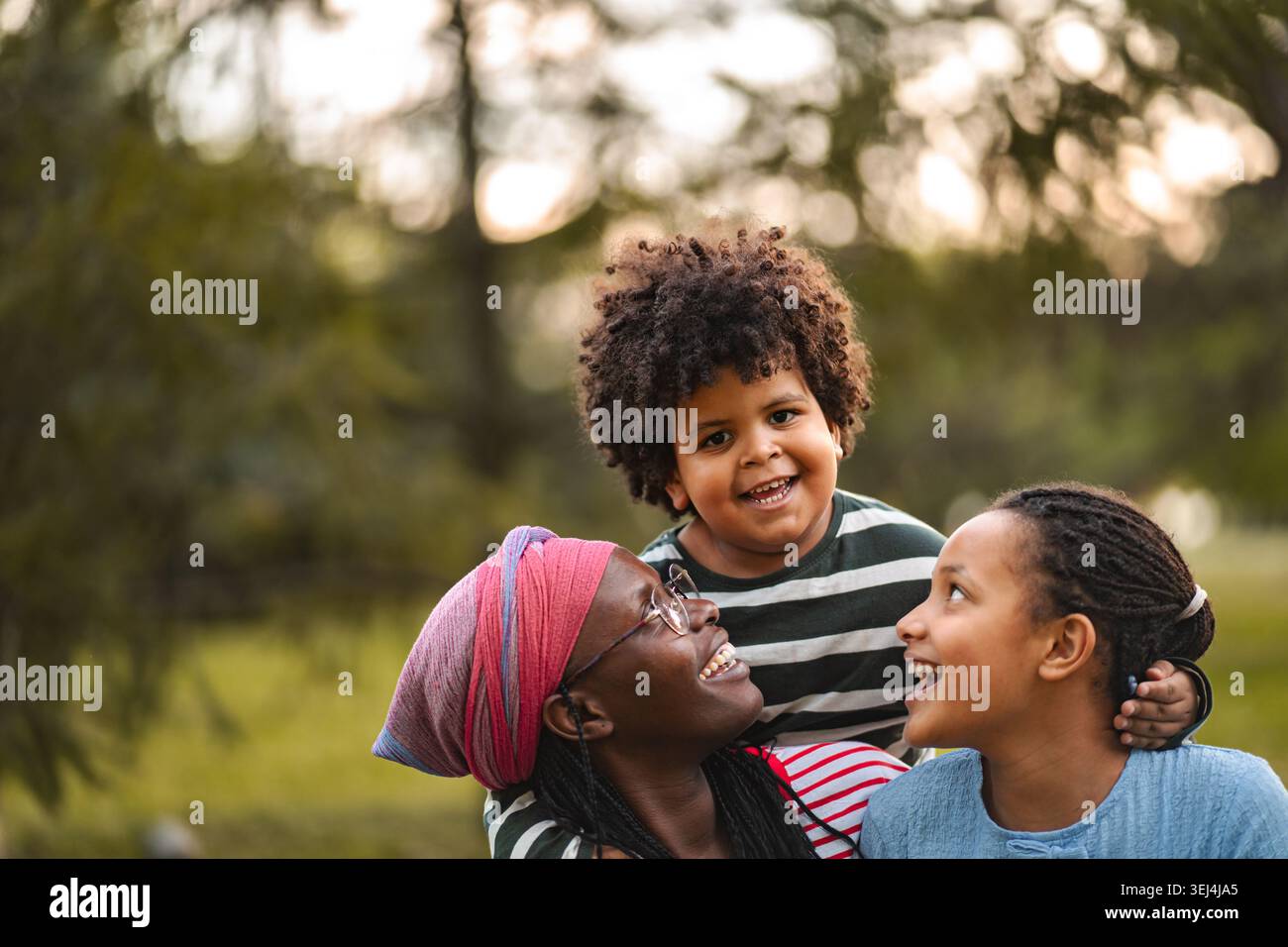 Madre e bambini ridono godendo il tempo libero in famiglia Foto Stock