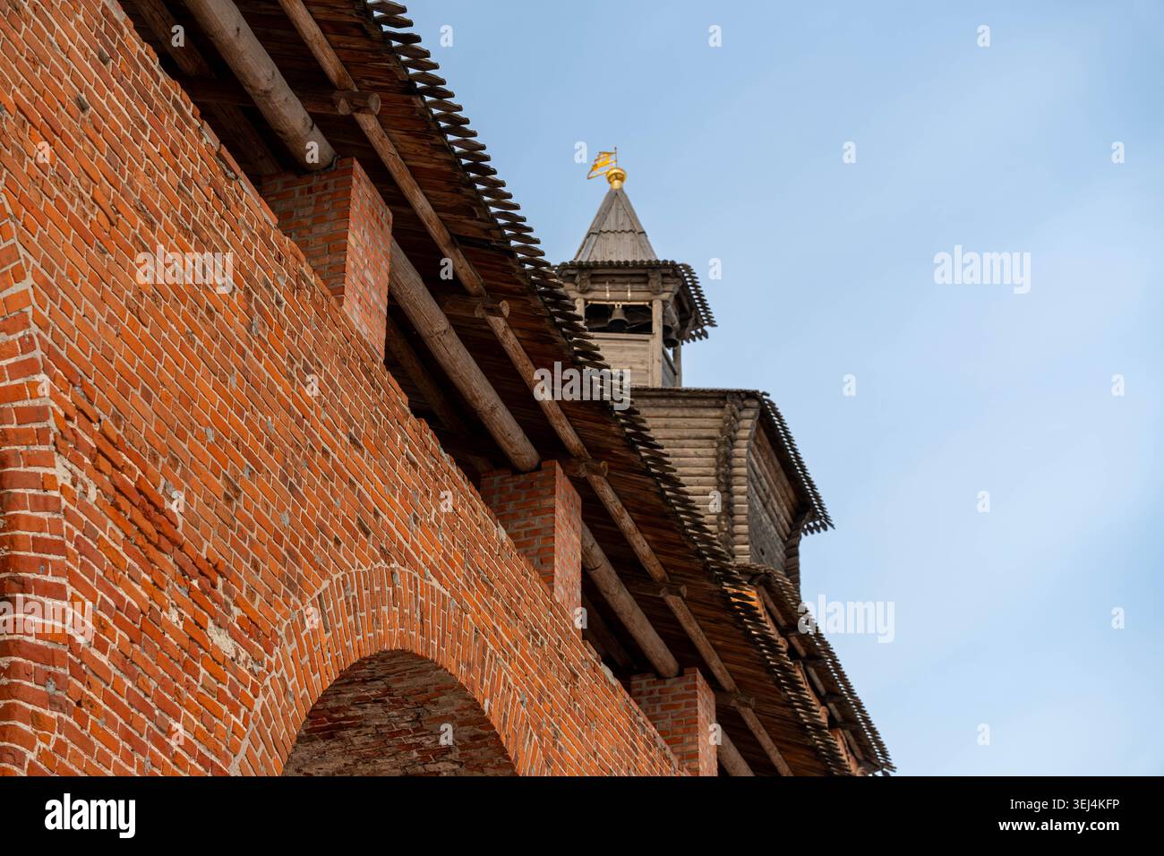 Torre della Fortezza in mattoni sotto il cielo pallido, Muraglia in mattoni rossi con archi tondi, guglie in legno coronate da croce dorata, tessuti in muratura intemprati, Foto Stock