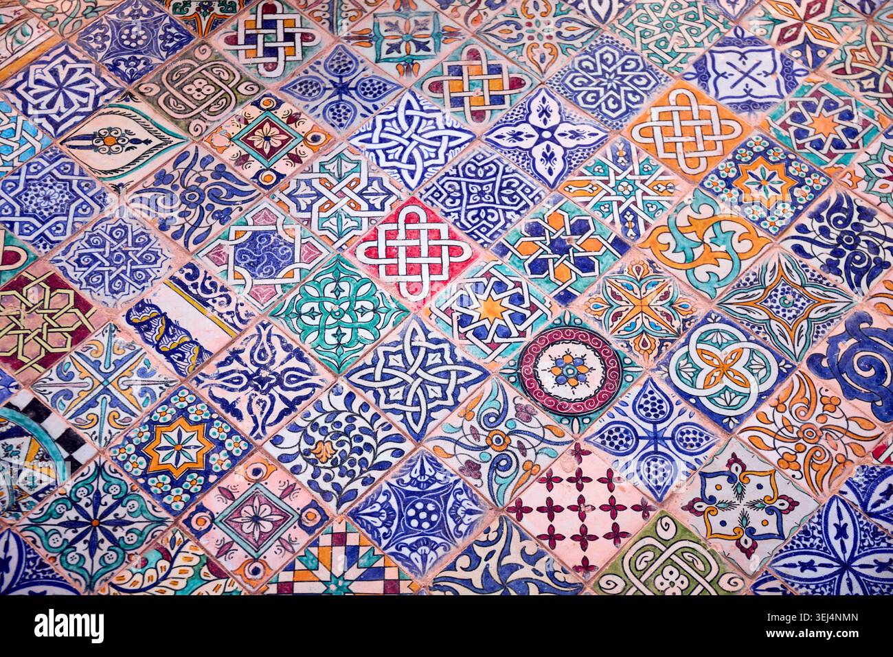 Le vivaci piastrelle mostrano una gamma di motivi geometrici e colori, che riflettono l'arte insegnata alla scuola di ceramica di Fez, in Marocco. Ogni pezzo Foto Stock