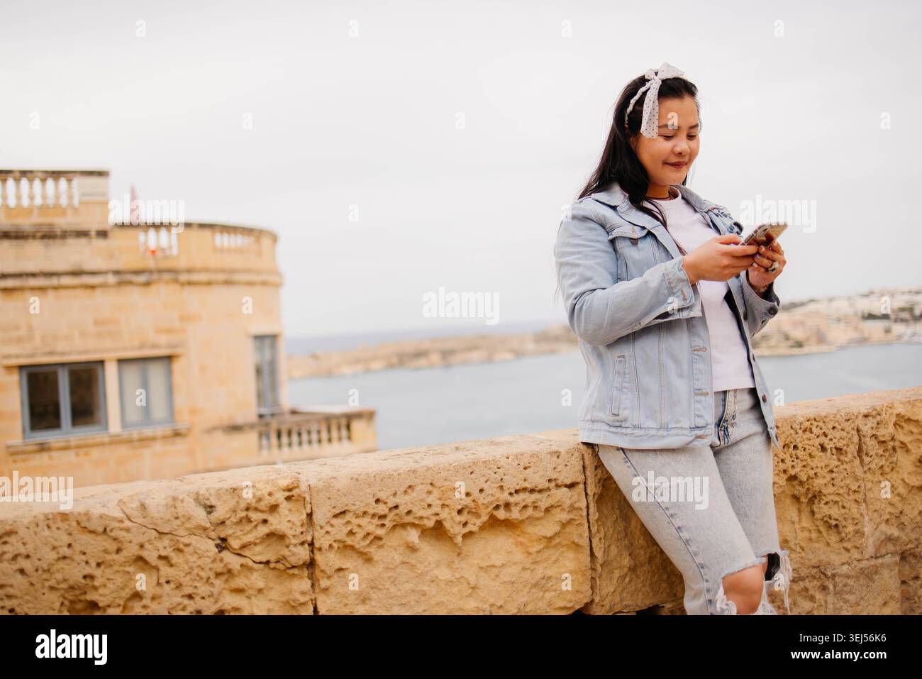 Donna che usa il telefono nella città vecchia Foto Stock