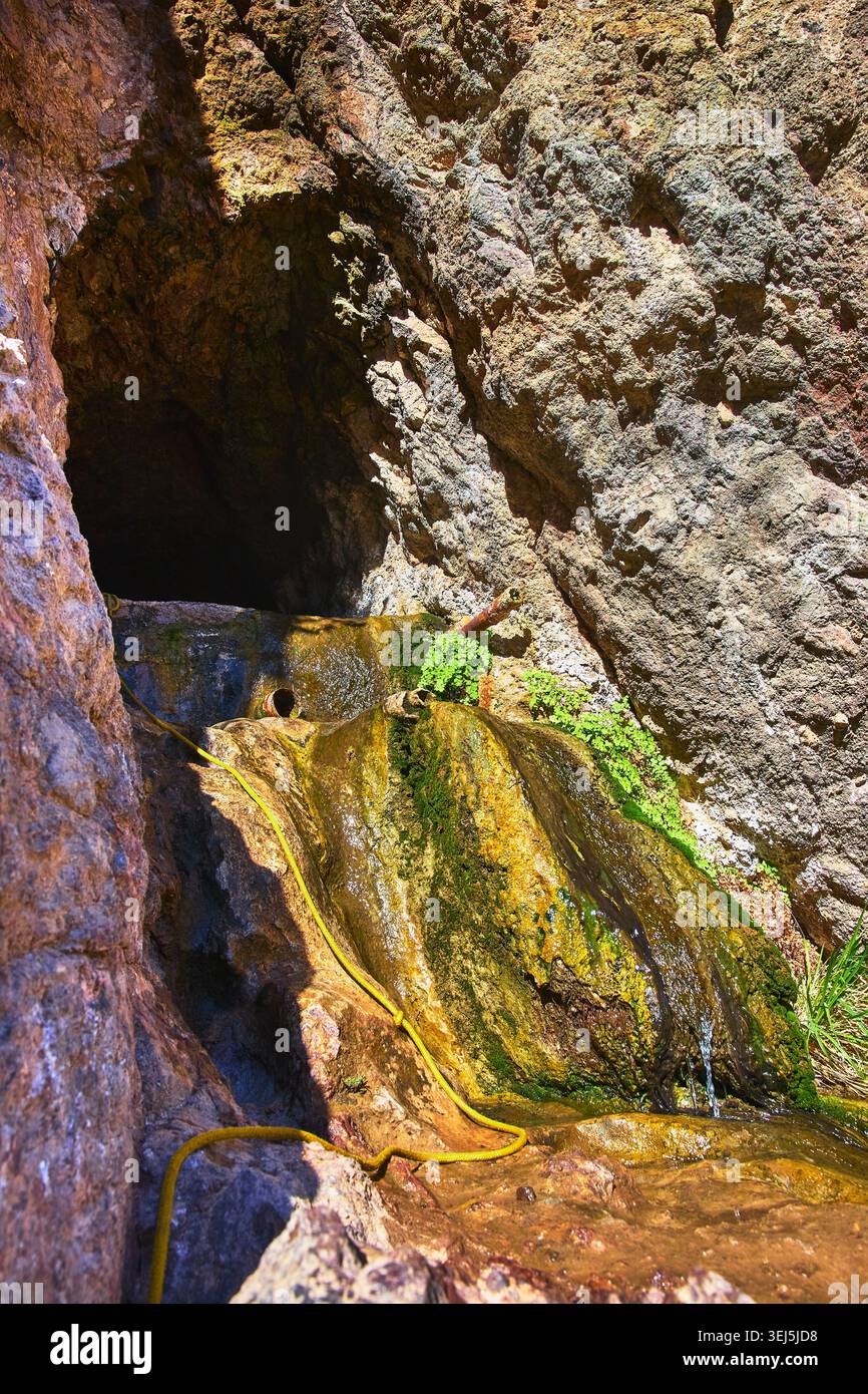 Ingresso alla Grotta delle sorgenti termali di Goldstrike, acqua fluente e Mossy Rocks alla luce del sole Foto Stock