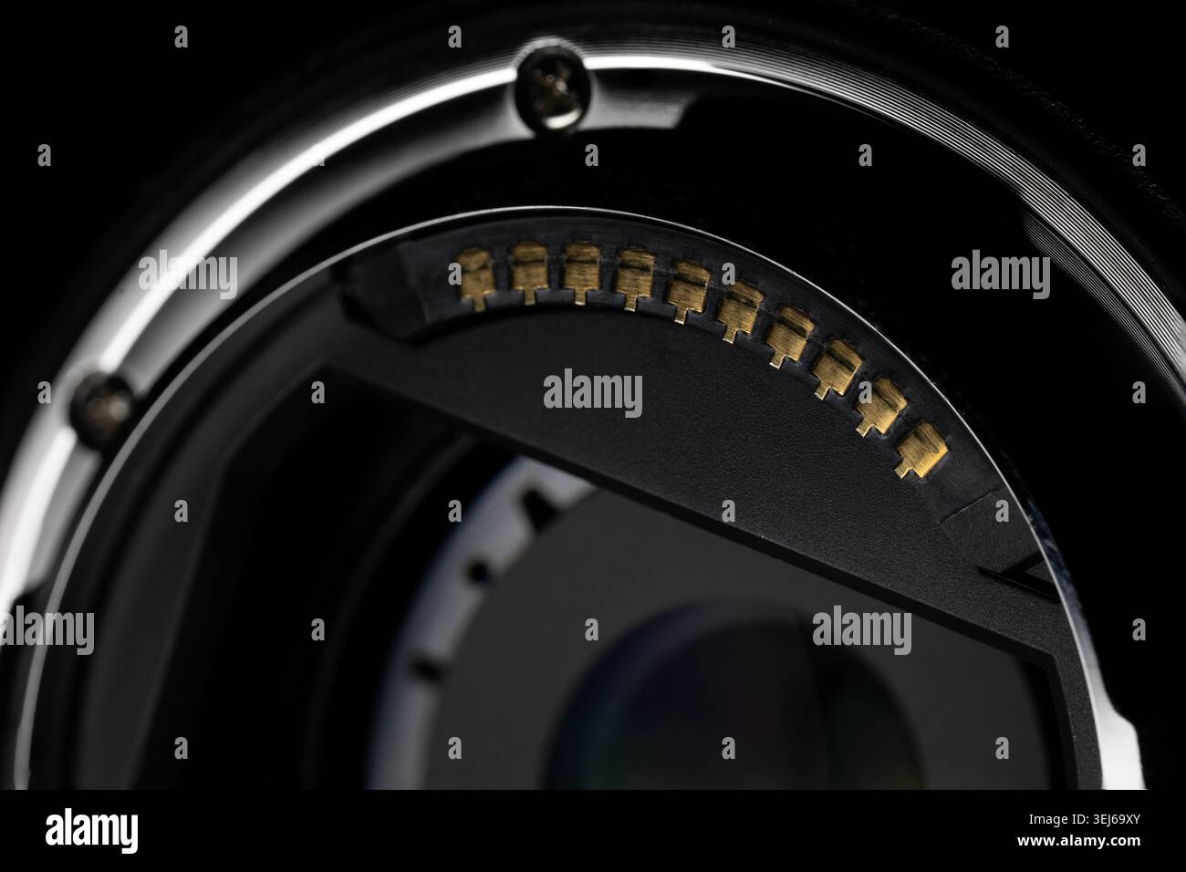 Foto macro dettagliata dei contatti elettronici dell'obiettivo della fotocamera con illuminazione soffusa sul nero Foto Stock
