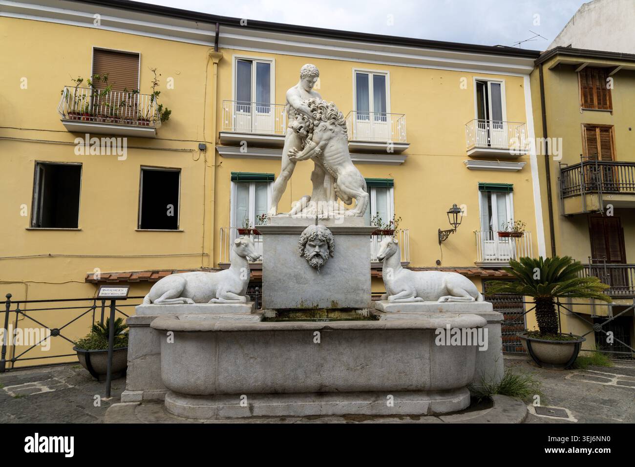 Sessa Aurunca - Campania - Italia - 08-29-2025: Statua della fontana di Erkules con eroe che lotta leone su lavabo di marmo, fiancheggiata da animali sdraiati, set Be Foto Stock