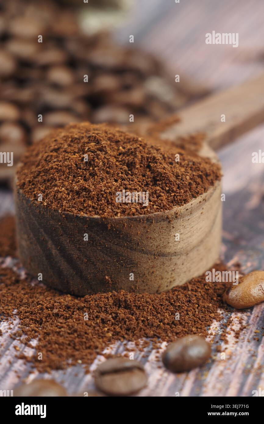 Il caffè appena macinato si trova in un misurino in legno Foto Stock