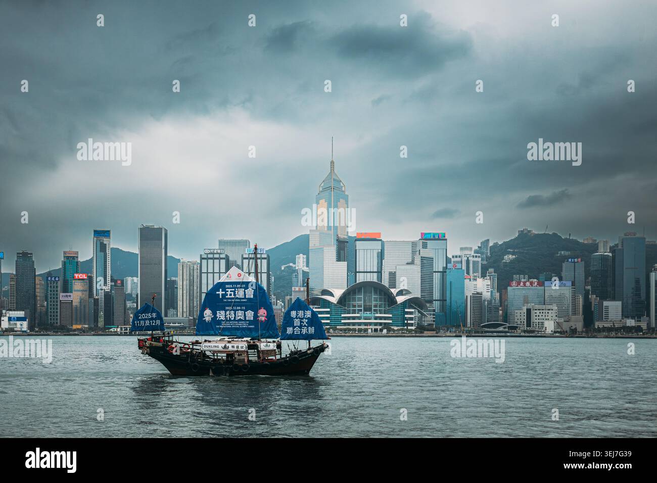 Tradizionale barca a vela Dukling junk nel Victoria Harbour con bandiera dei Giochi nazionali Foto Stock