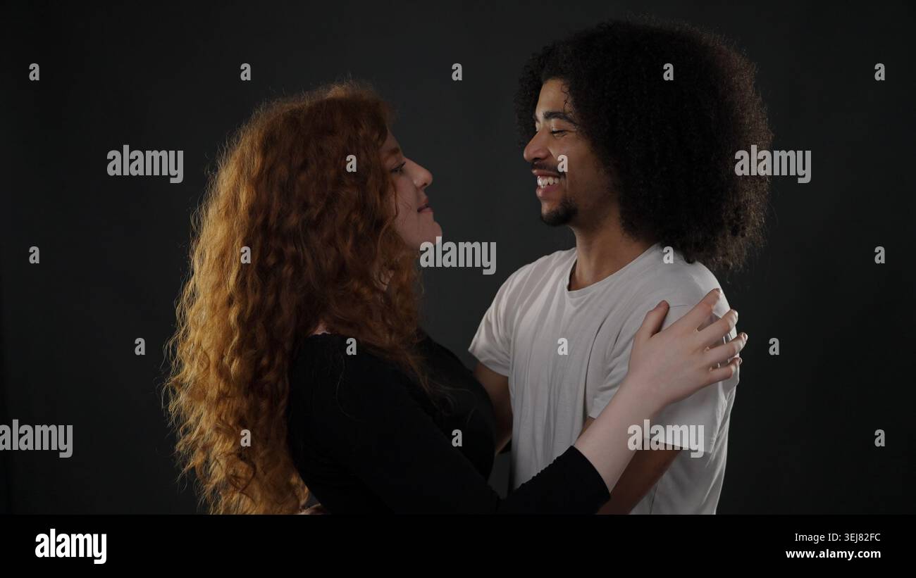 Felice giovane coppia che esprime amore e felicità mentre abbraccia in uno studio Foto Stock