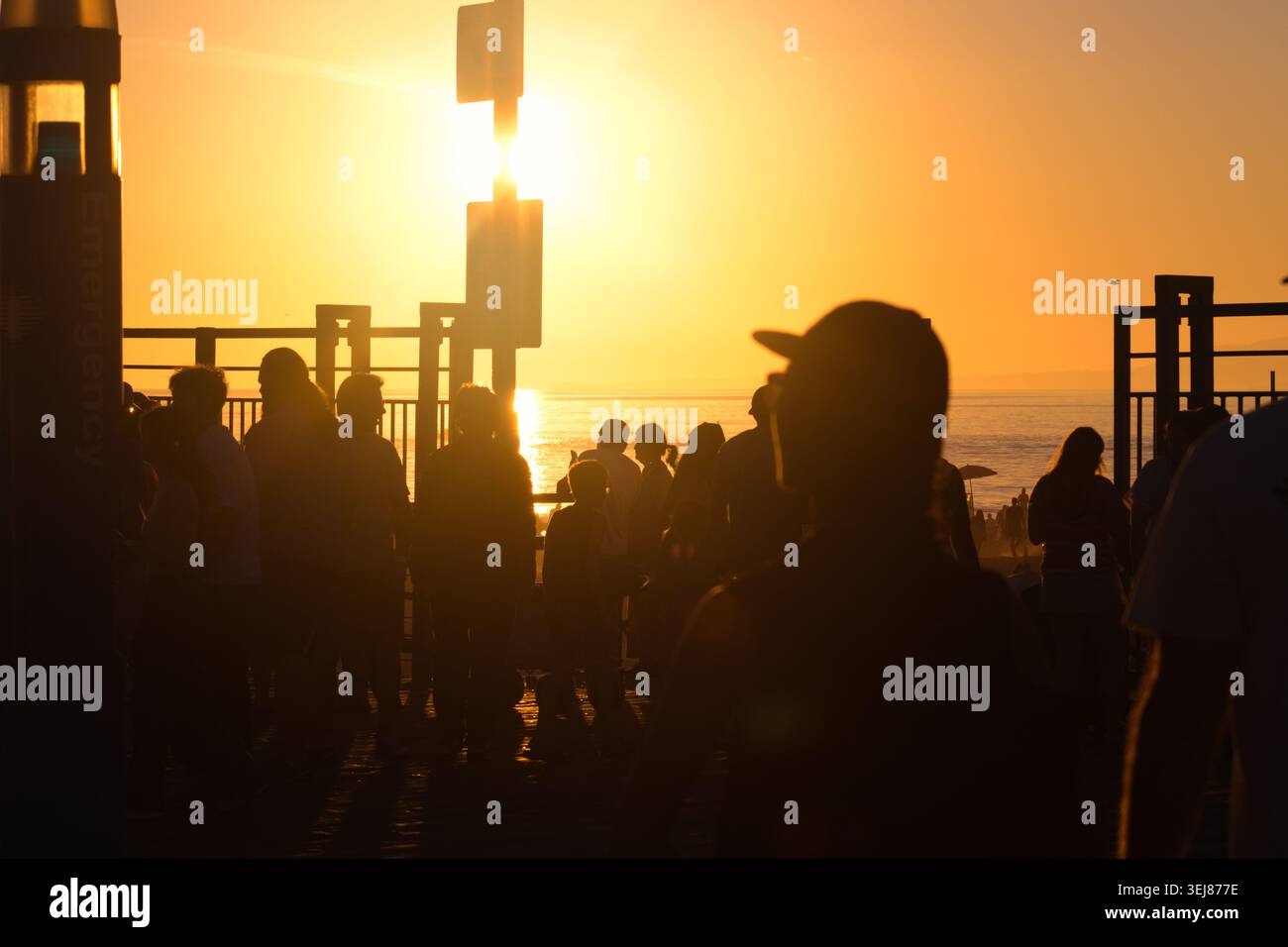 La folla guarda il tramonto al molo di Santa Monica in California Foto Stock