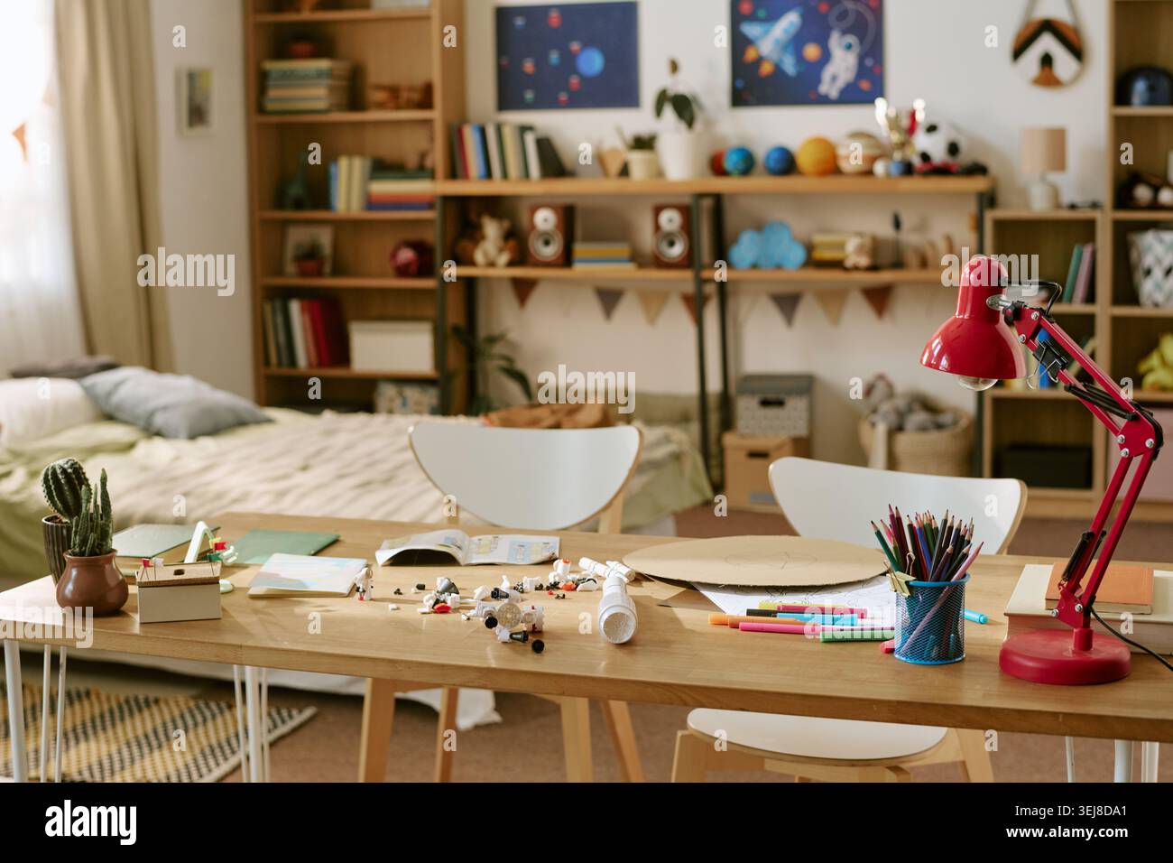 Spazio studio per la camera da letto per bambini con forniture scolastiche e arredi a tema spaziale Foto Stock