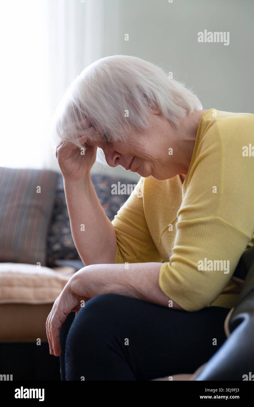 Donna anziana che soffre di mal di testa a casa, ritratto di nonna anziana depressa con emicrania che tiene la testa Foto Stock