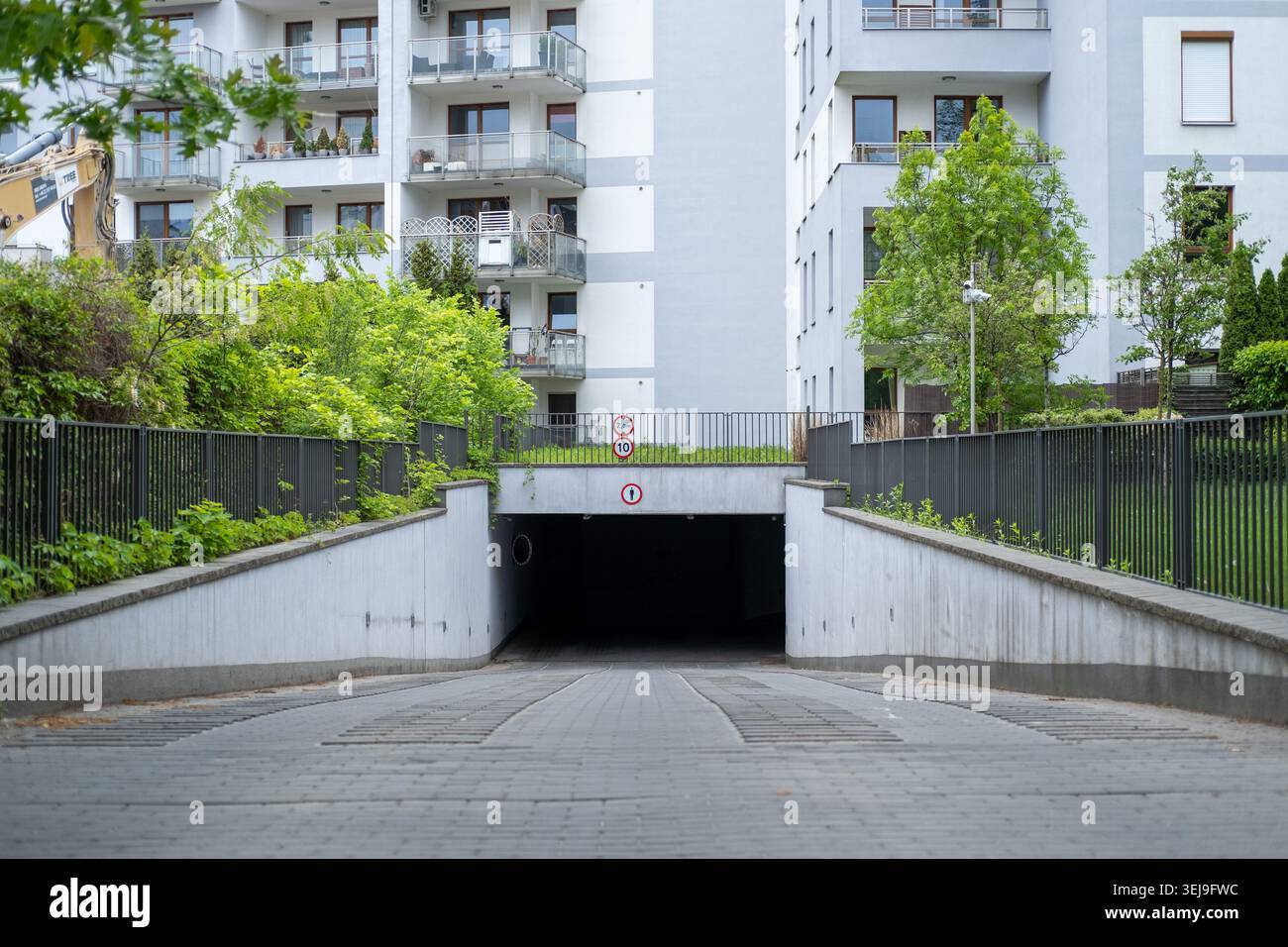 Rampa verso il basso per un garage sotterraneo in un moderno complesso residenziale. Foto Stock