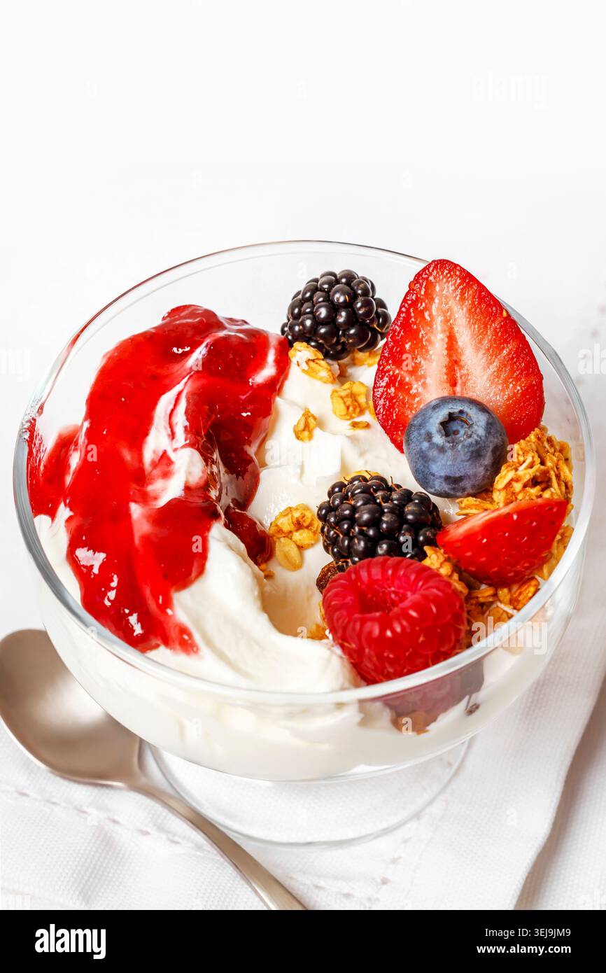 Yogurt bianco con frutti di bosco, muesli e marmellata di bacche Foto Stock