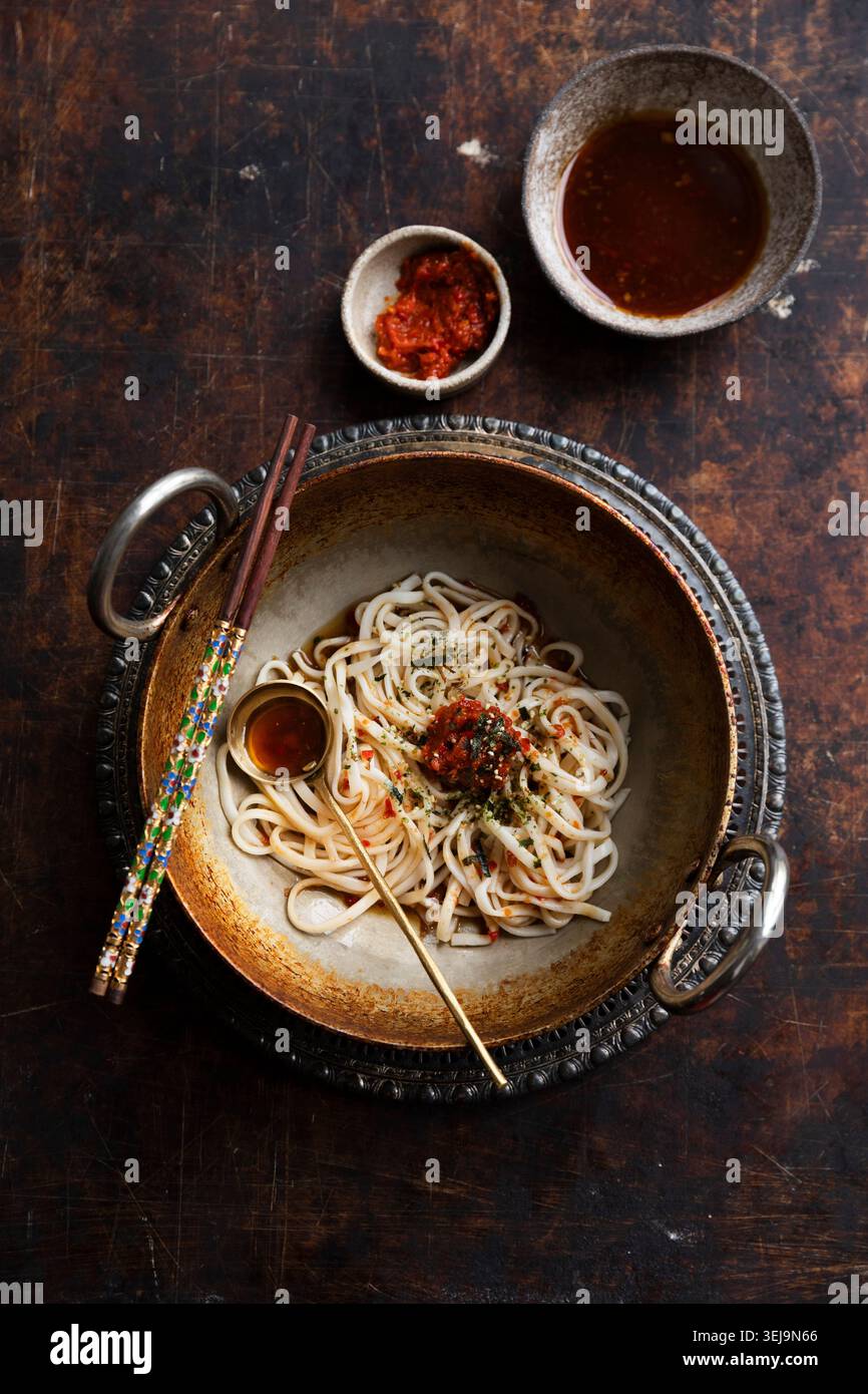 Spaghetti udon piccanti con pasta di peperoncino e contorno alle alghe Foto Stock