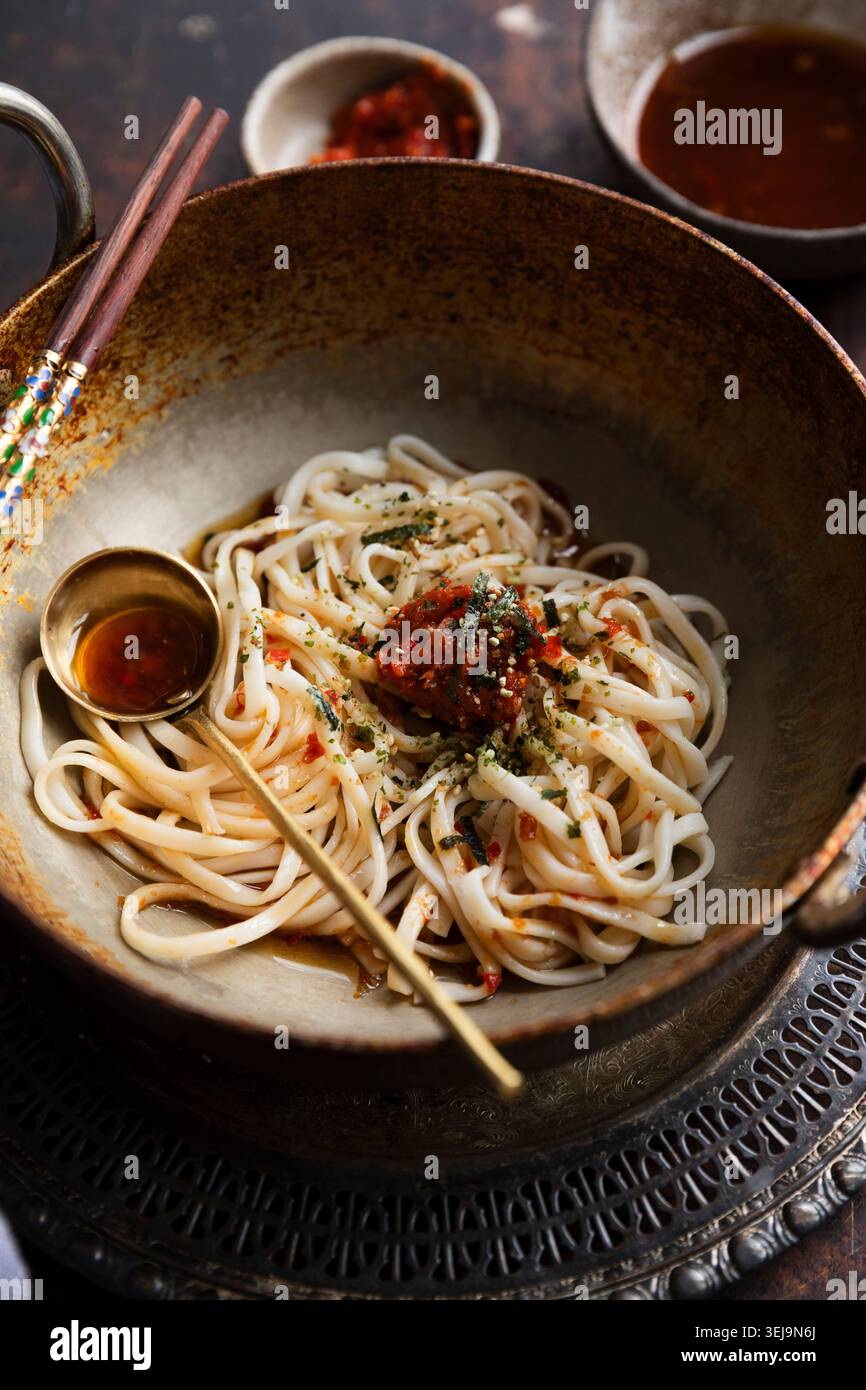 Spaghetti udon piccanti con pasta di peperoncino e contorno alle alghe Foto Stock