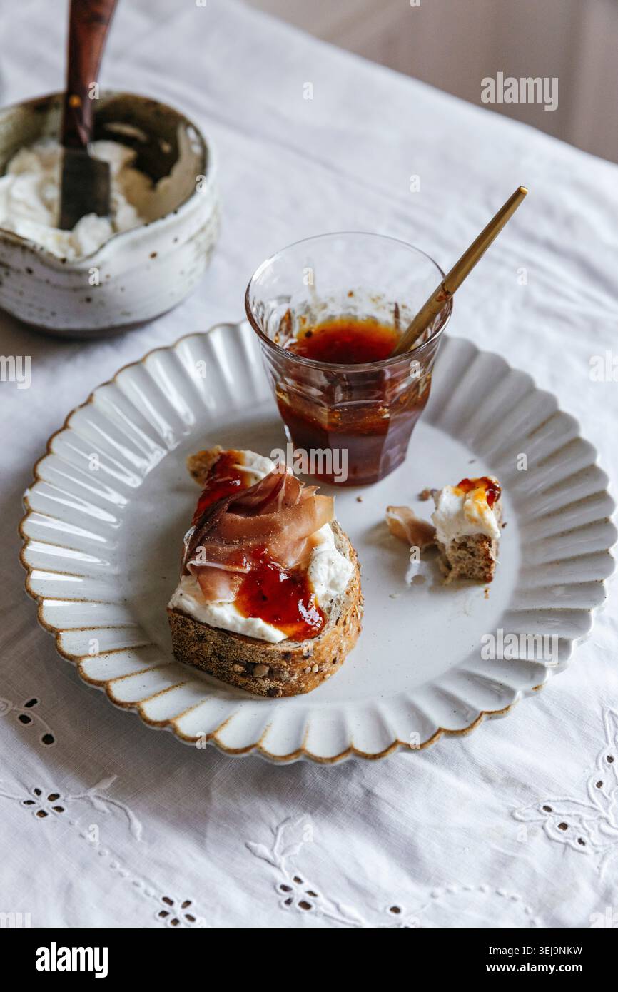 Toast a lievito madre con prosciutto, ricotta e marmellata sul piatto Foto Stock