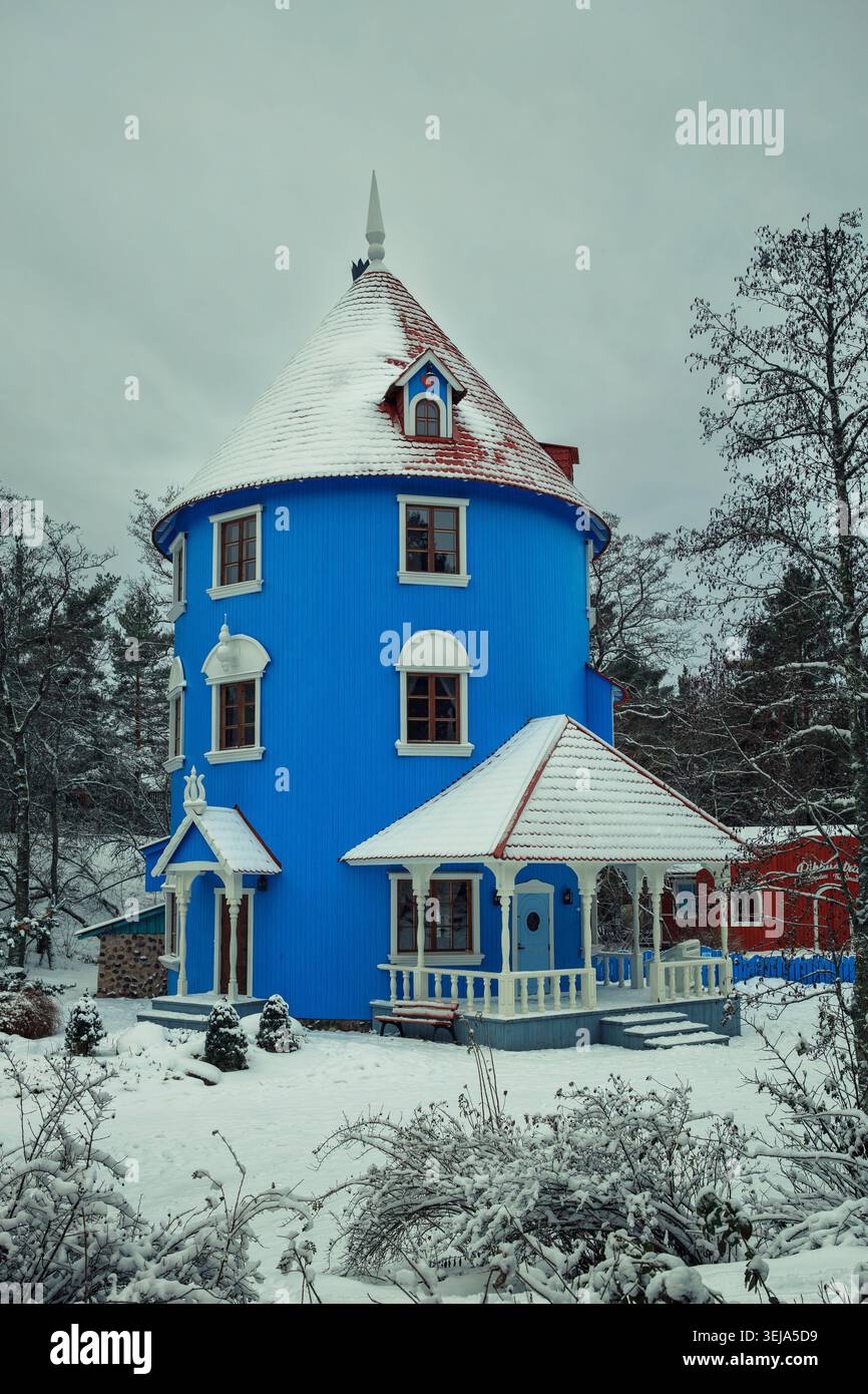 NAANTALI, FINLANDIA - 27.12.2023: L'iconica casa blu Moomint coperta di neve invernale nel parco a tema Moominworld (Muumimaailma). Foto Stock