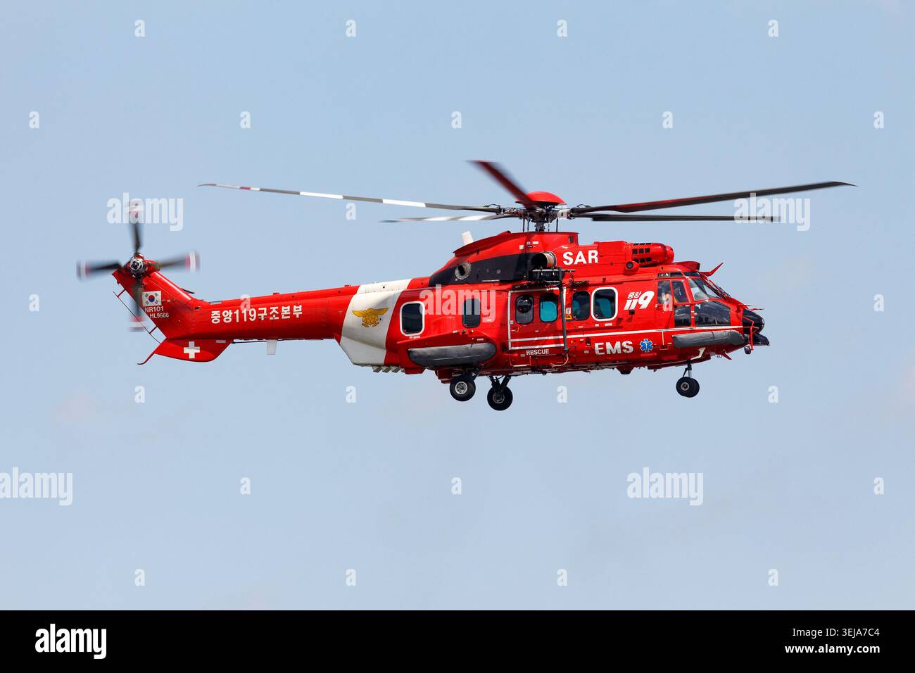 Un elicottero rosso sudcoreano 119 Rescue Headquarters di ricerca e salvataggio che vola in un cielo azzurro, equipaggiato per i servizi di emergenza a Seoul, Corea Foto Stock