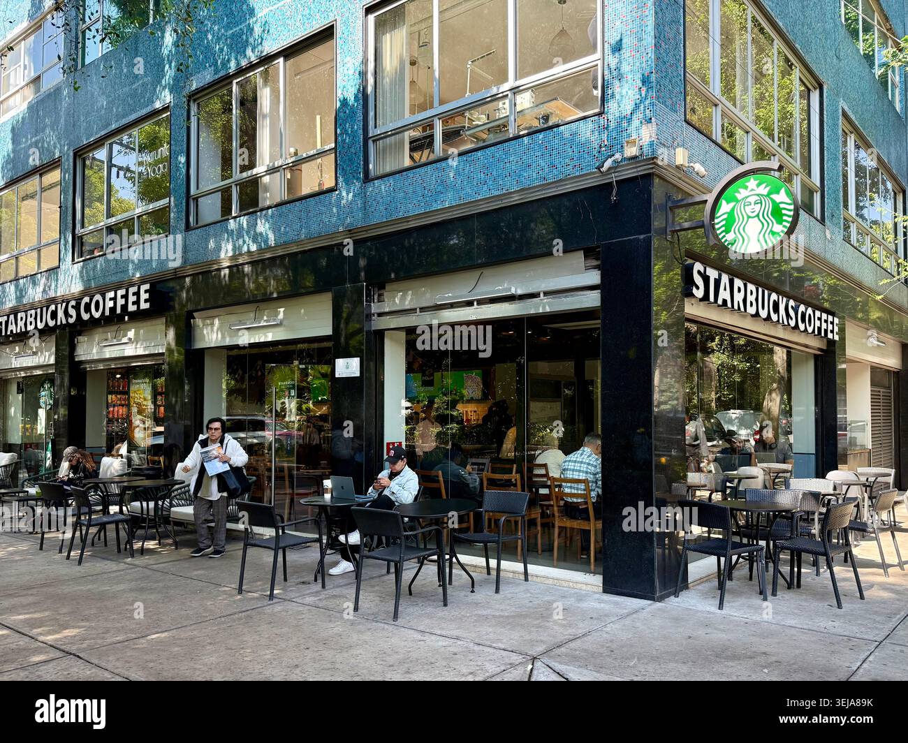 Una filiale di caffè Starbucks con posti a sedere all'aperto a Roma Norte, città del Messico, che illustra le catene di caffè globali, la cultura urbana dei consumatori e la gentrificatio - Immagine stock catturata con smartphone