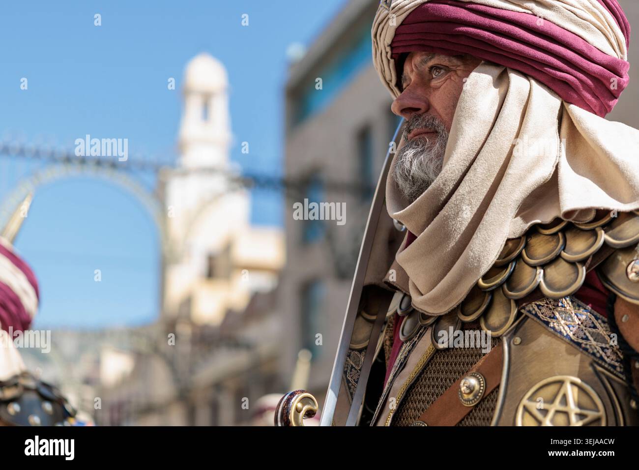 Cavalieri del capitano nella processione delle reliquie al festival dei mori e dei cristiani, con la torre del Santo Sepulcro ad Alcoy, Spagna, 26 aprile 2026 Foto Stock