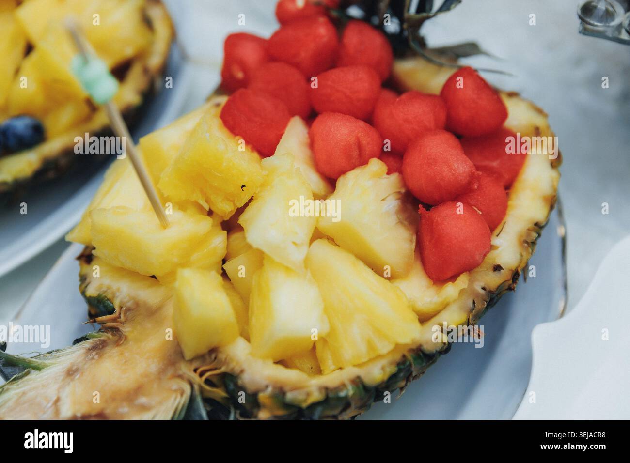 Ananas mezzo ripieno di frutta dorata Foto Stock