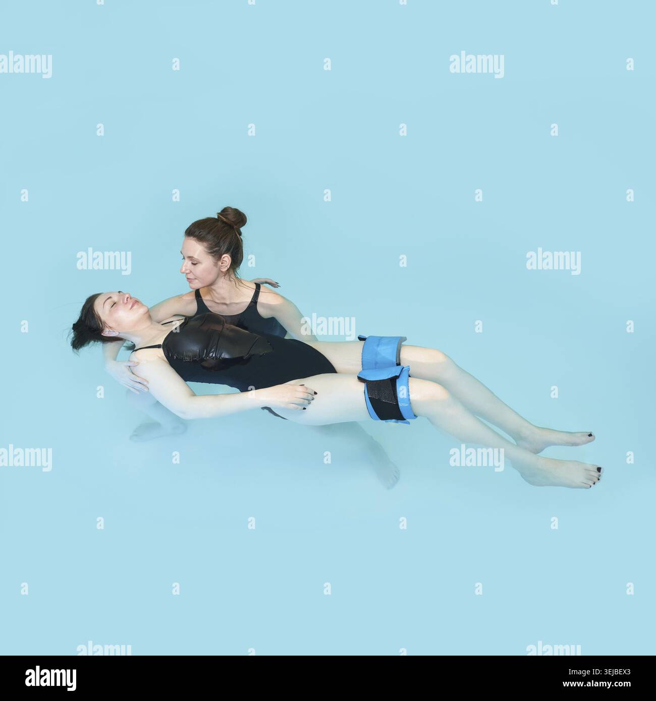 Donne adulte che praticano la terapia acquatica per il relax e la riabilitazione in piscina Foto Stock