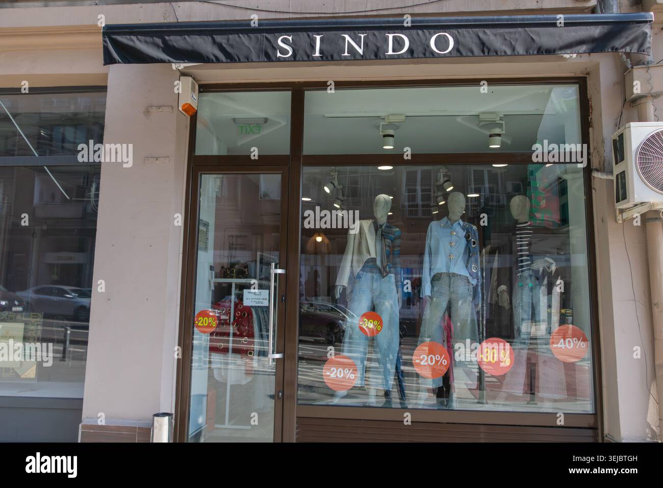 Moderno negozio di moda con manichini e colorati adesivi di vendita scontati esposti in un quartiere commerciale - Bucuresti, Romania - 15 marzo Foto Stock