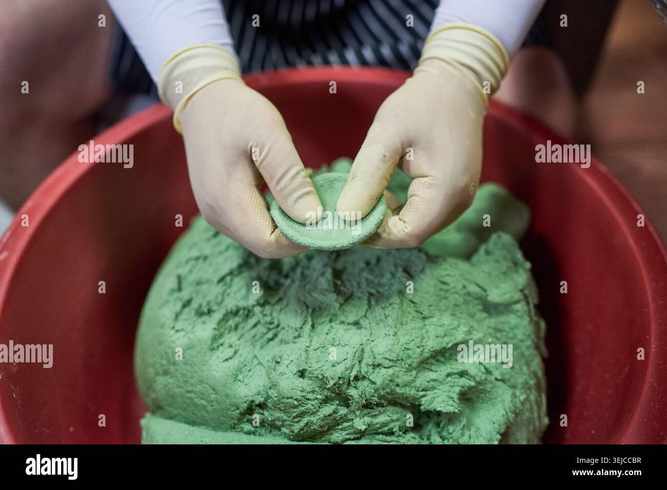 Le foto mostrano la preparazione delle tradizionali torte coreane di riso a base di mugwort, dalla sagomatura dell'impasto verde a mano al prodotto finale lucido al vapore. Foto Stock