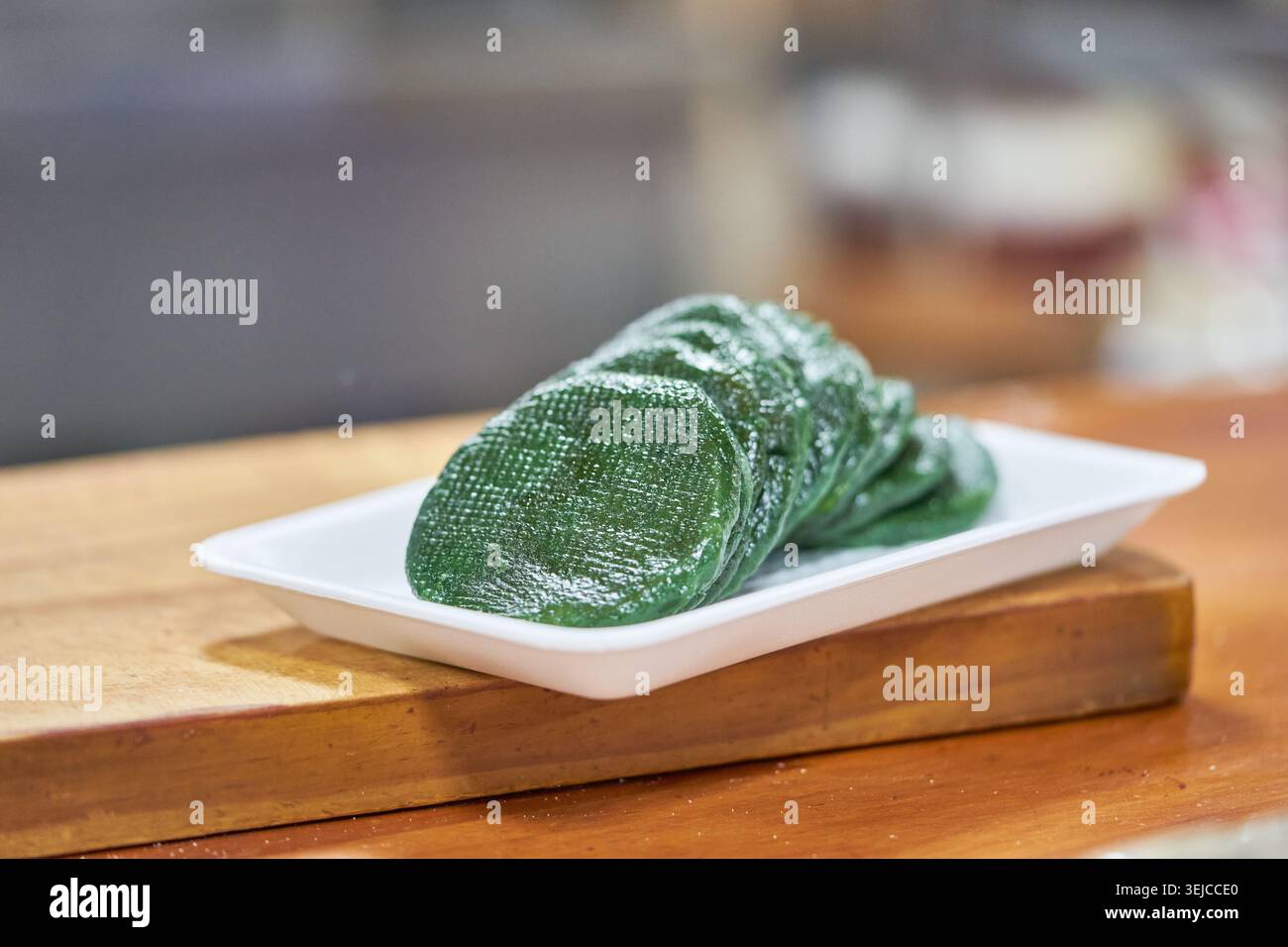 Le foto mostrano la preparazione delle tradizionali torte coreane di riso a base di mugwort, dalla sagomatura dell'impasto verde a mano al prodotto finale lucido al vapore. Foto Stock