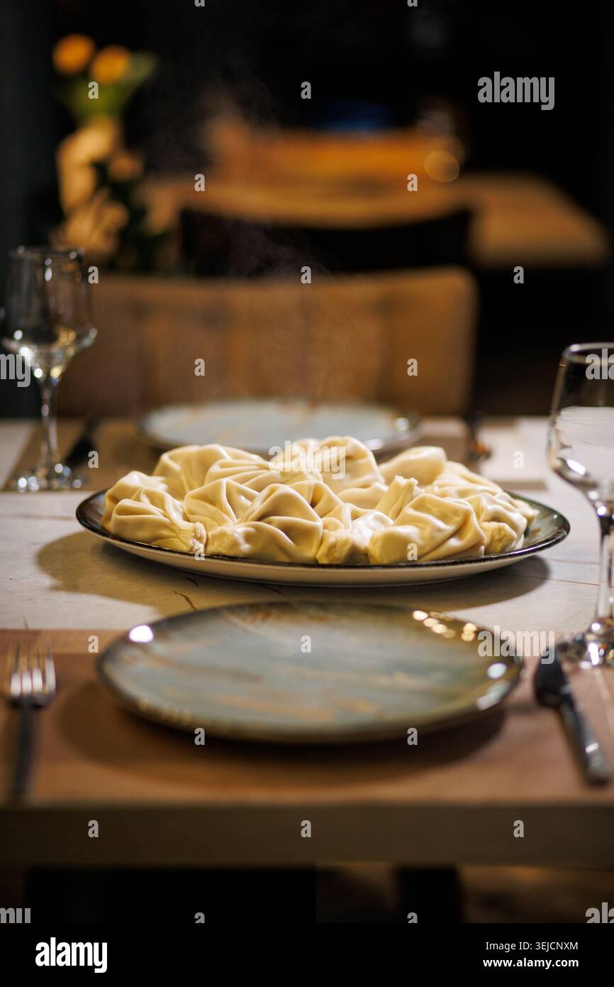 Guinzaglioli Khinkali tradizionali georgiani serviti su piatto nel tavolo da cena del ristorante Foto Stock