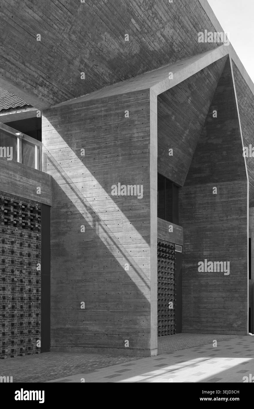 Architettura in cemento brutalista con forti linee geometriche, ombre drammatiche, composizione urbana minimalista. Foto Stock